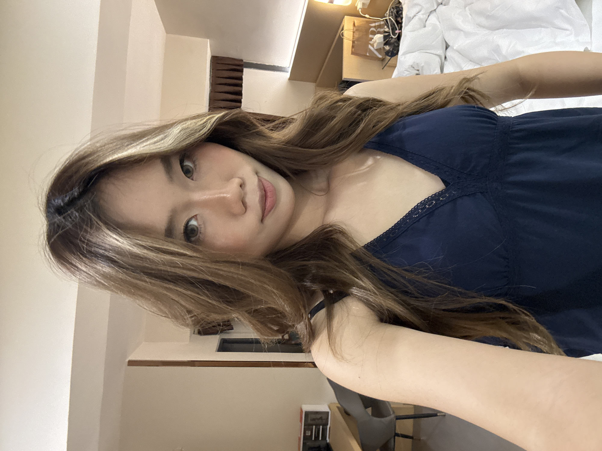 A woman is lying in a bedroom. The woman has brown hair and is wearing a blue top. The location is a bedroom, with a bed and other furniture visible. The precise location in Yuzhong District, China cannot be determined from the image.