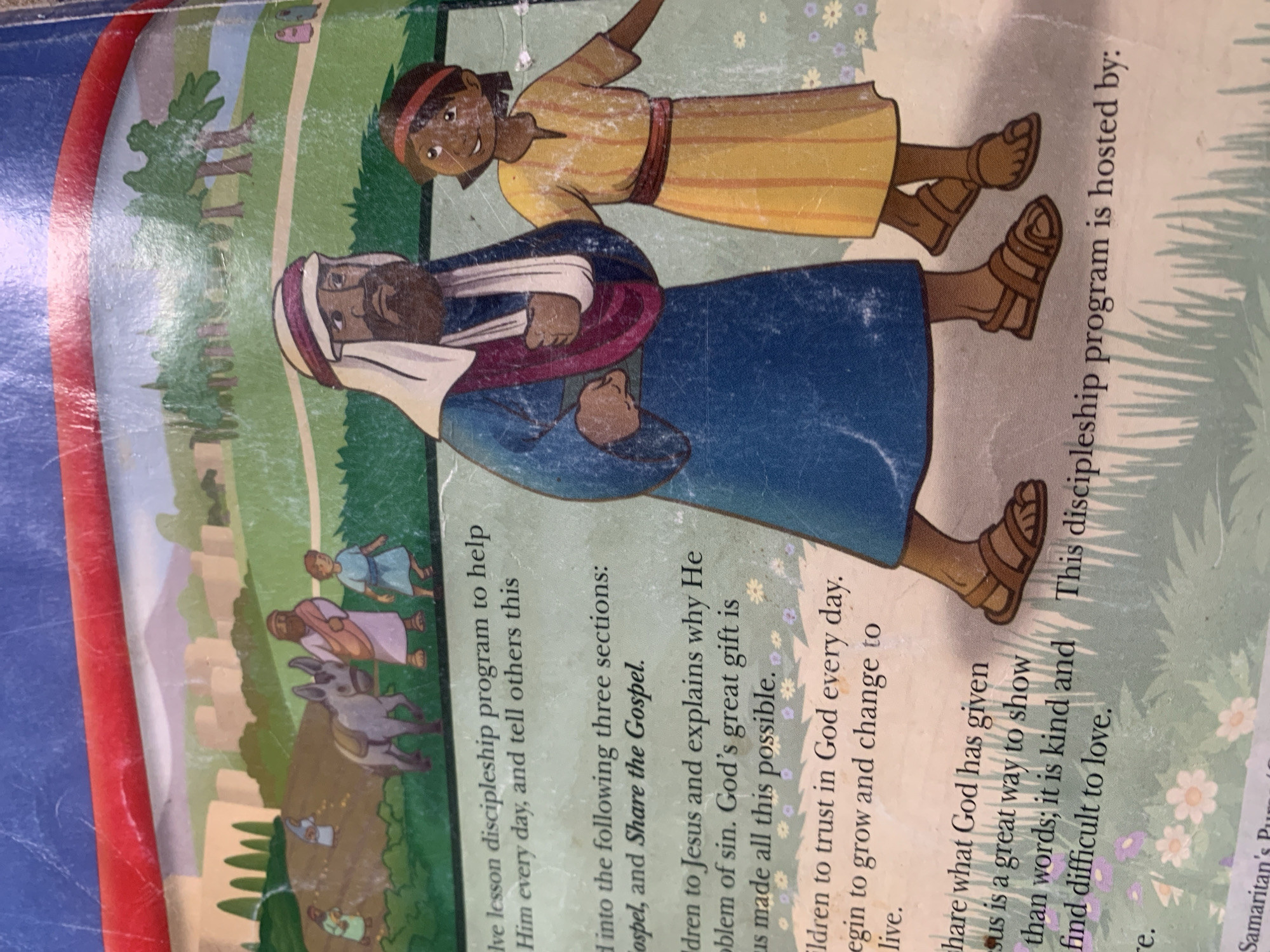 The image shows a page from a book, featuring an illustration of two figures in a rural setting. A man with a beard and a white head covering, dressed in a blue robe and a maroon sash, stands next to a young girl in a yellow dress. They are walking on a dirt path, with a grassy area and scattered flowers to their right. In the background, there are rolling hills, buildings, and trees. The text on the page discusses a discipleship program. There is no information in the image that indicates a location in Jauro Yinu, Nigeria.