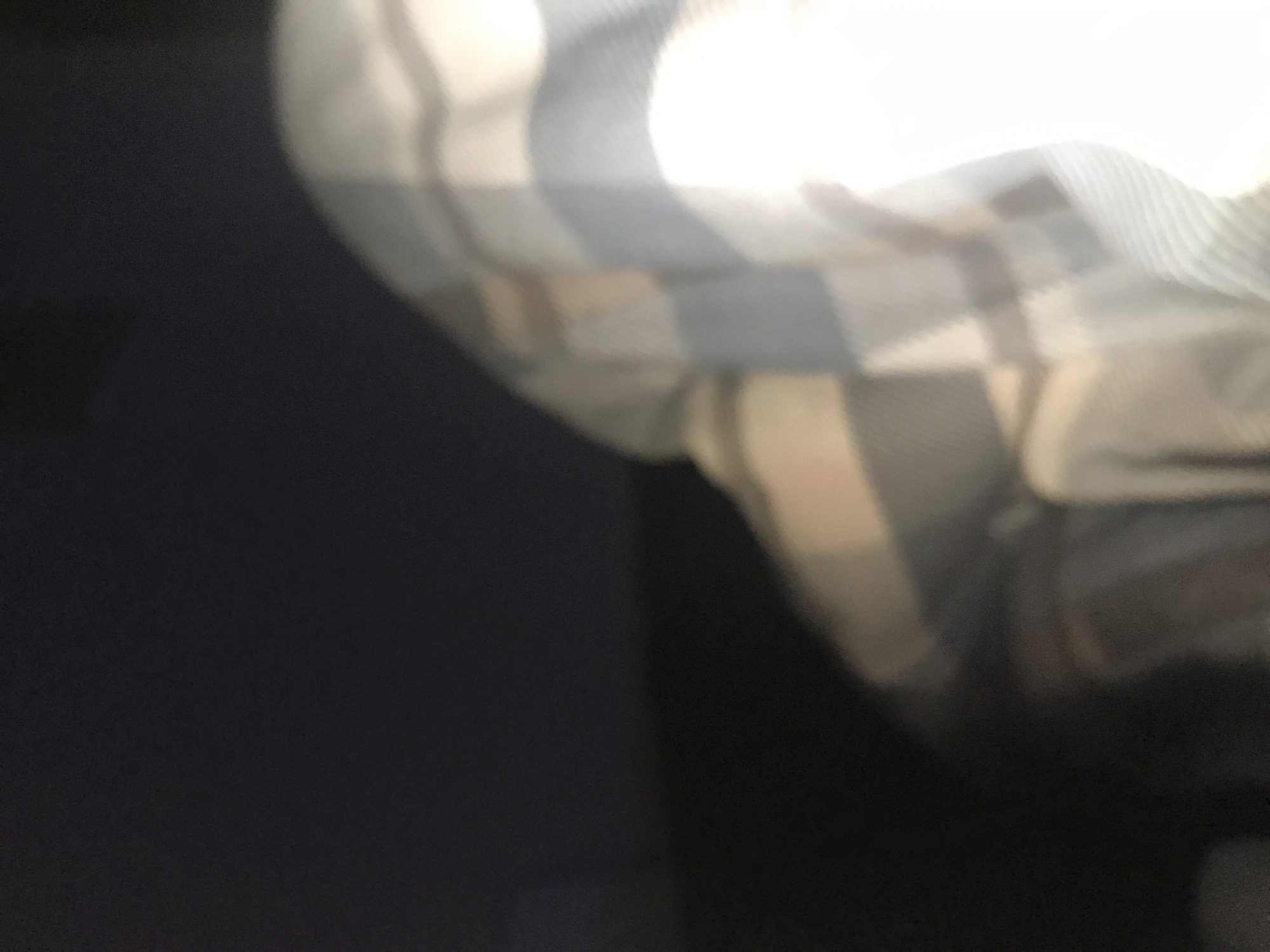 The image is blurry and poorly lit, making detailed forensic analysis difficult. The right portion of the image shows a blurred, out-of-focus plaid pattern. The left portion is dominated by a dark, undefined area. There is no information to identify the location in Yerevan, Armenia, or details about any people, objects, actions, or interactions.