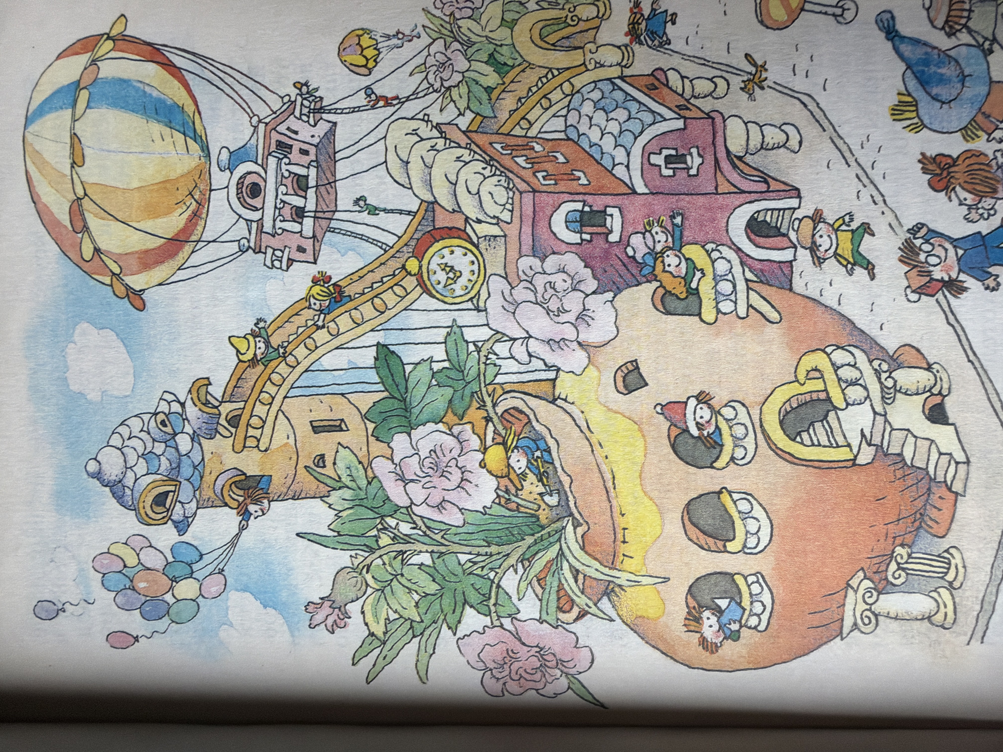 The image is an illustration from a children's book depicting a whimsical, fantastical scene with a variety of elements. In the upper left, a child with red hair holds a bunch of colorful balloons, floating near a tower with a scaled, blue roof. Above and to the right, a pink and yellow striped hot air balloon carries a small, multi-story house. A yellow slide leads from a tower down towards the ground, with several children playing on it. A large clock with a red frame is visible on the slide's structure. In the foreground, a large, orange, bulbous-shaped house with arched windows and columns stands on the left. Flowers and greenery spill from an opening in this structure. To the right of the orange house is a smaller, pink, brick-like building with windows and an arched doorway. Several children are depicted in and around these structures, some peeking out of windows or playing. A small cat is shown running on the ground. In the lower right, a group of children are gathered, one wearing a blue hat. The overall scene is brightly colored and imaginative. The location in the city of Папярнянскі сельскі Савет, Belarus, is not depicted or inferable from the provided image.