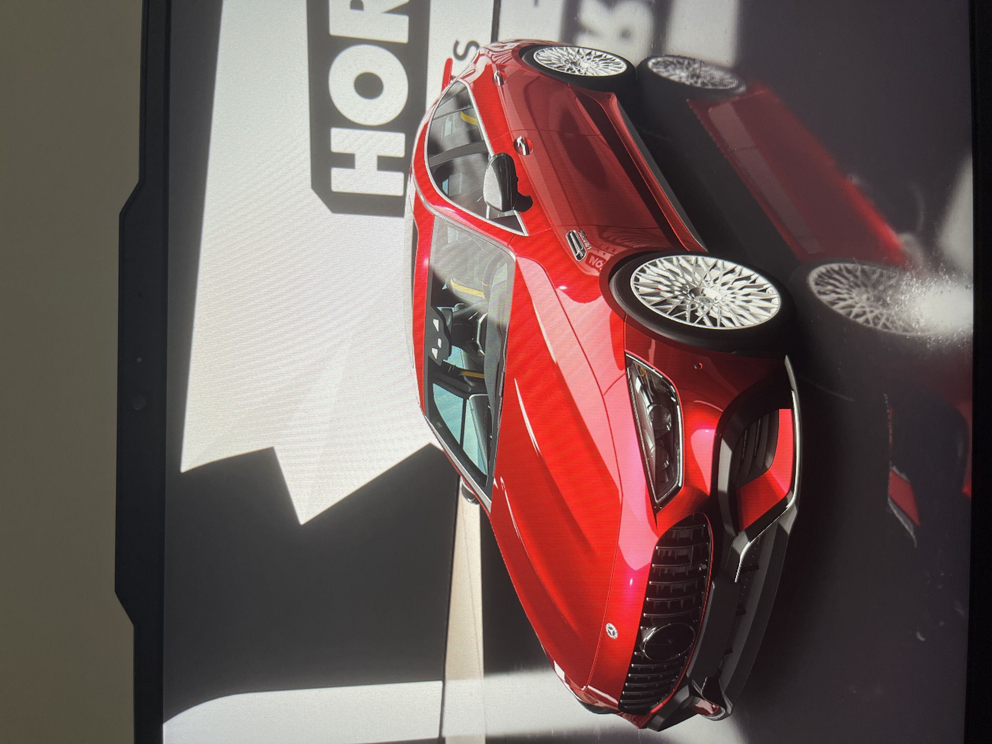 The image shows a red Mercedes-AMG GT 63 S parked on a surface with white and dark gray patterns. The letters "HOR" are visible in the background. The location is Unknown, Unknown.