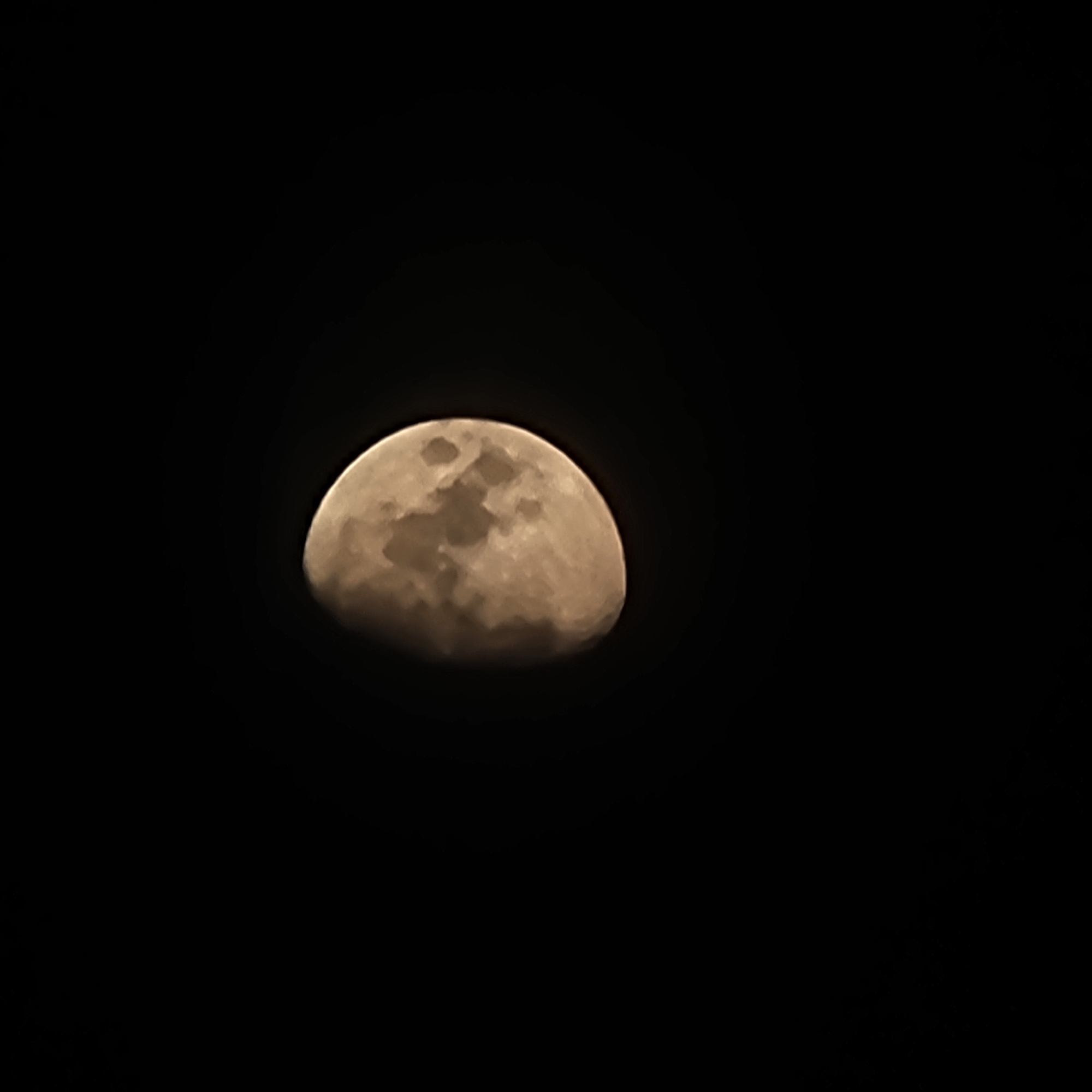 The image is a close-up, detailed photograph of the moon against a black background. The moon is partially illuminated, showing approximately half of its surface. The illuminated portion displays craters and other surface features, rendered in shades of off-white and light brown. The unilluminated portion is entirely black. The photograph is focused on the moon, with no other celestial bodies or terrestrial elements visible. The lighting suggests it is nighttime. The image does not contain any information about a city or location.