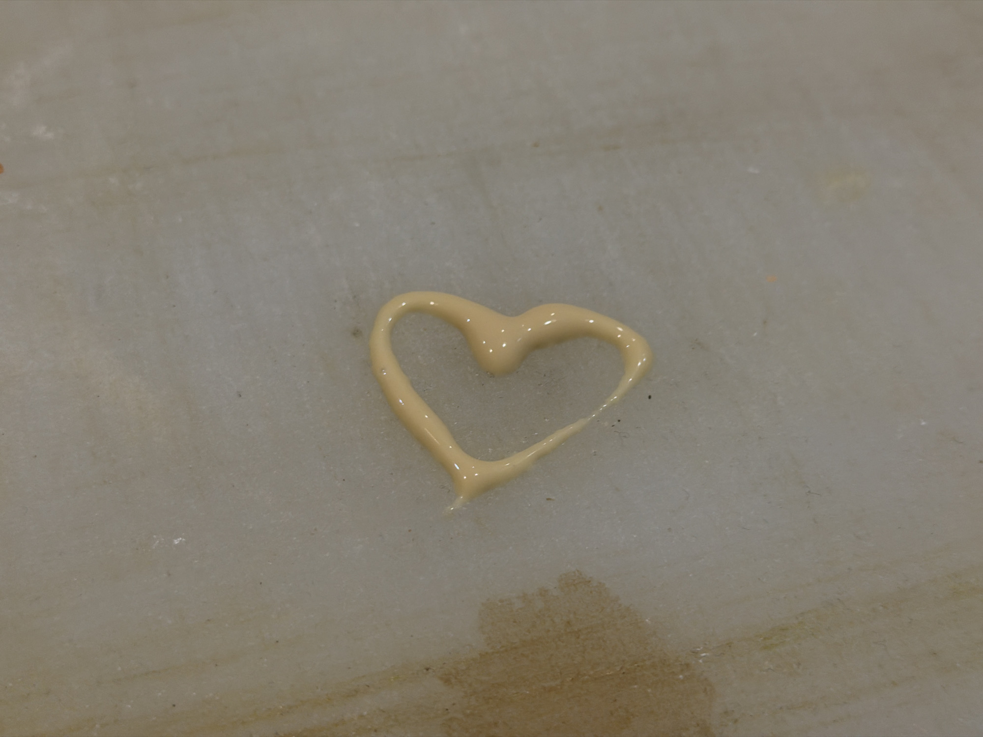 A heart shape, made of a viscous, beige-colored substance, rests on a light, possibly marble-like, surface. There is no evidence to determine that it is taken in Sofia, Bulgaria.