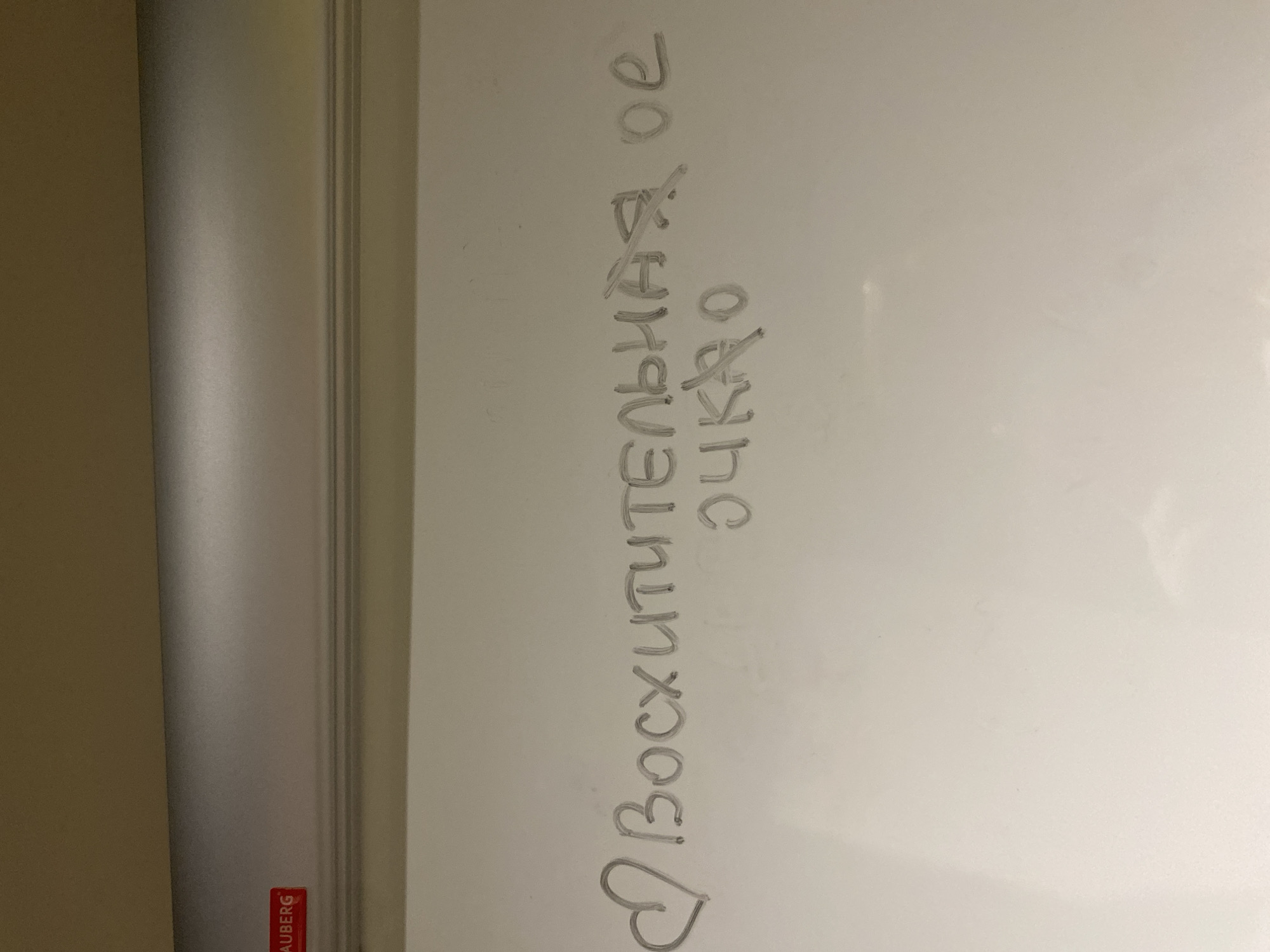 The image shows a whiteboard with a message written in Russian. The message starts with a heart symbol, followed by the word "ВОСХИТИТЕЛЬНАЯ," which translates to "wonderful" or "delightful." Below that is written the word "ОЧКО," which translates to "glass" but is crossed out. Then, a separate abbreviation "OE" can be seen which is crossed out. There is no information in the image to identify the location as Votkinsk, Russia. The whiteboard has a silver frame and the lower left corner shows the word "RAUBERG".