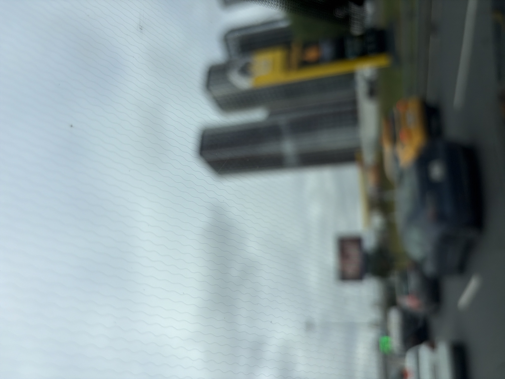 The image depicts a blurry street scene, likely taken from inside a vehicle, showing several cars in traffic. In the background, several tall, modern buildings are visible, suggesting an urban environment. A yellow taxi is also present in the traffic. The sky is overcast. The image is out of focus, making it difficult to discern specific details of the cars or buildings. The presence of tall buildings and traffic suggests this could be a business district or a busy thoroughfare in a city. Without further information or clearer details, it is not possible to definitively identify the specific location in Moscow, Russia.