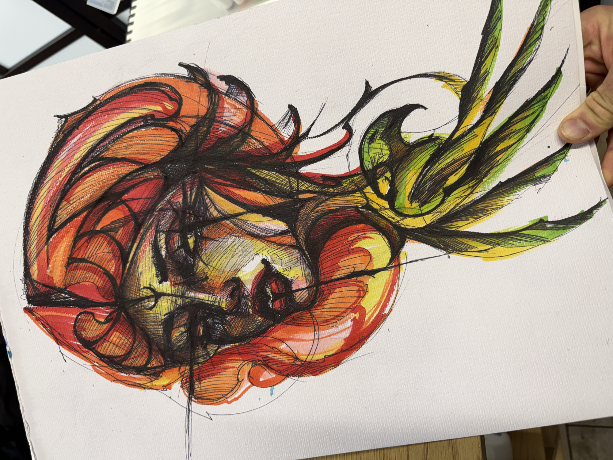 The image is a close-up of an artwork, likely a drawing or painting, depicting a stylized face or figure. The artwork is dominated by curvilinear shapes and bold outlines in black. The figure is surrounded by organic forms resembling petals or leaves, colored in shades of red, orange, yellow, and green. The artwork is on a white canvas or paper. Part of a hand is visible holding the canvas. The image provides no information related to the city of Sofia, Bulgaria.