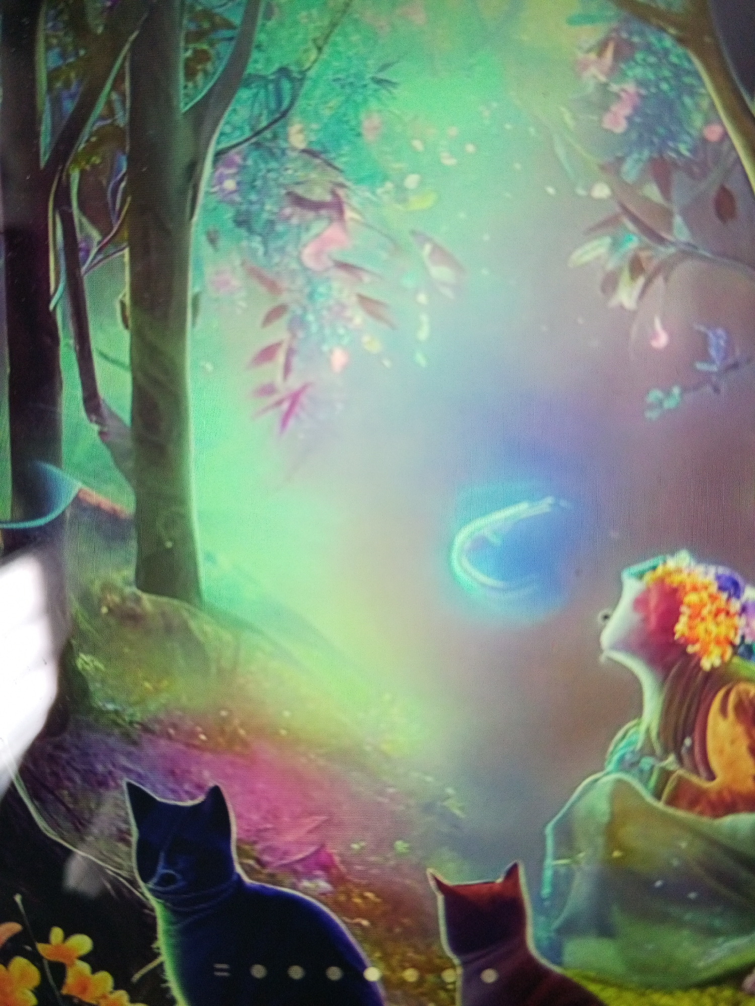 The image depicts a fantastical scene, likely a digital illustration or artwork. In the foreground, there are two stylized cats, one primarily black and the other a reddish-brown. They are positioned near yellow flowers. Behind them, a woman with a flower crown sits in a brightly colored, otherworldly environment that appears to be a forest. The scene is filled with light and ethereal elements, including a glowing orb in the upper right quadrant. The environment features trees, leaves, and a blend of pastel colors. The location in the city of Tinaquillo, Venezuela is unknown, as it is impossible to ascertain such information from the depicted content.