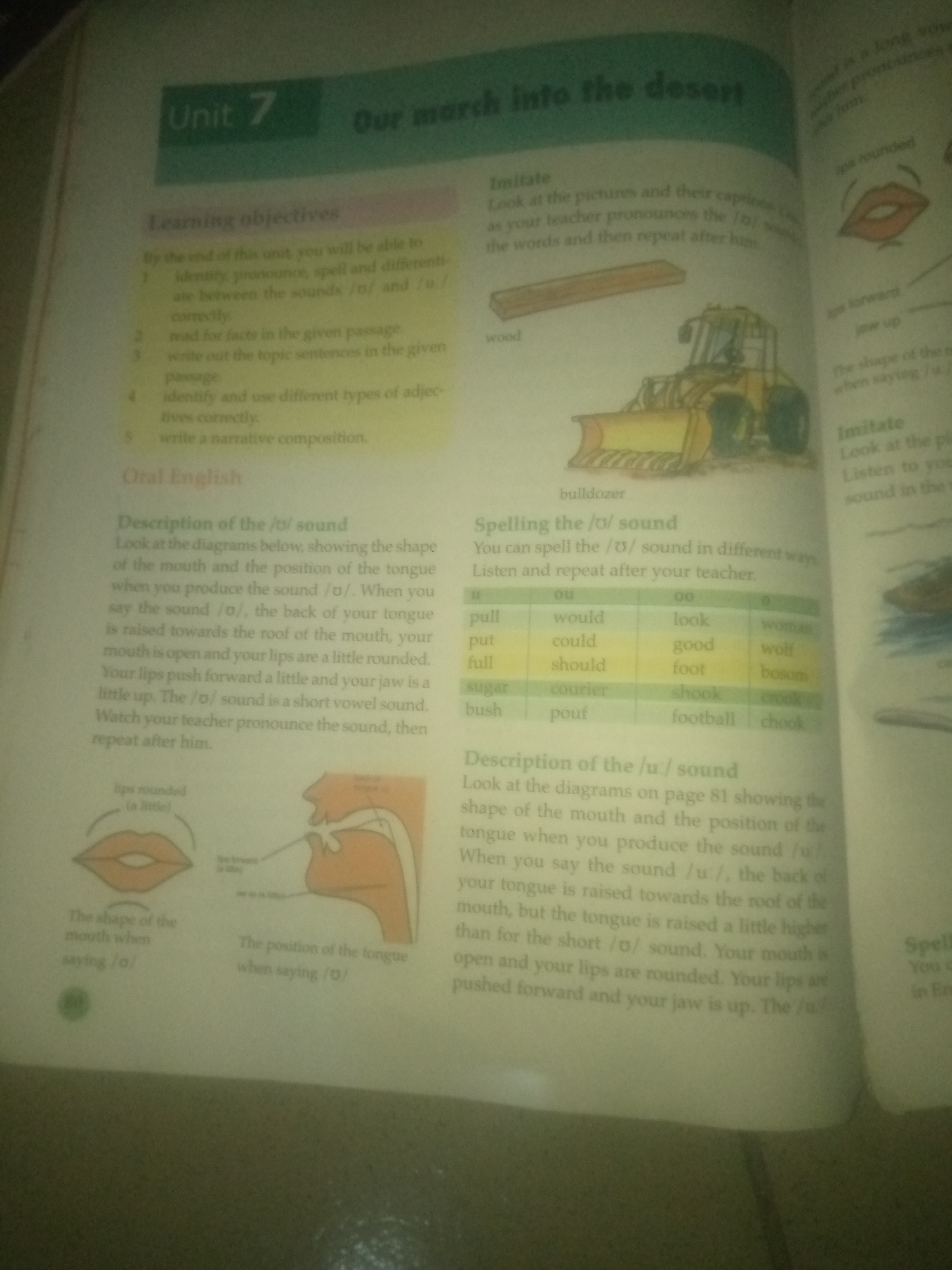 The image is a photograph of a page from a textbook, likely for English language learning. The page is divided into several sections, each with headings and accompanying text or diagrams.
At the top of the page, the title "Our marsh into the desert" is visible, along with "Unit 7". Below this are "Learning objectives," which are listed numerically.
Further down, there is a section titled "Imitate," which includes instructions to look at pictures and their captions and pronounce sounds. A picture of a wooden plank and a bulldozer is present, with the word "wood" and "bulldozer" below them, likely as examples.
Another section is titled "Oral English," followed by "Description of the /o/ sound." This section provides a detailed explanation of how to produce the /o/ sound, accompanied by diagrams illustrating the shape of the mouth and the position of the tongue when saying the sound.
Below this, a table is presented under the heading "Spelling the /o/ sound." The table contains columns with different spellings and corresponding words that produce the /o/ sound, such as "pull," "would," "look," and "woman."
Towards the bottom right of the image, there is a section titled "Description of the /u:/ sound," which appears to be a continuation of the phonetics lesson, with a similar setup of text and possibly diagrams (though the diagrams are not fully visible).
There are no visual elements in the image that indicate a location in Jauro Yinu, Nigeria, or any specific city. The context is solely that of an educational textbook.