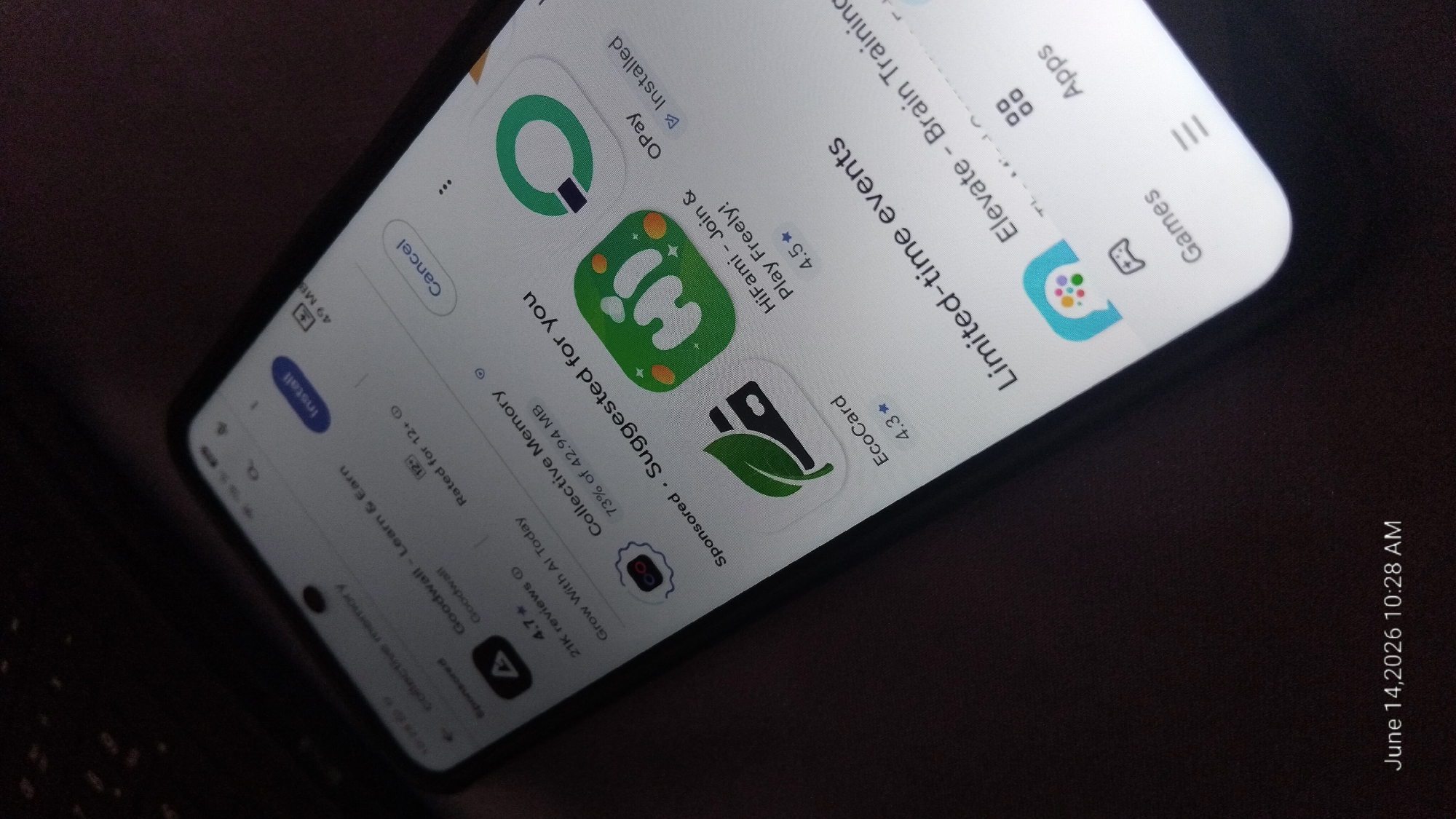A smartphone screen displays an app store interface. The screen shows a list of applications, including "Goodwall - Learn & Earn," "Collective Memory," "HiFami - Join & Play Freely!," "EcoCard," and "OPay." Some apps have "Install" or "Installed" buttons. The interface also includes sections like "Sponsored - Suggested for you" and "Limited-time events." A date and time stamp at the bottom of the screen reads "June 14, 2026 10:28 AM." The background of the image is a dark, textured surface.