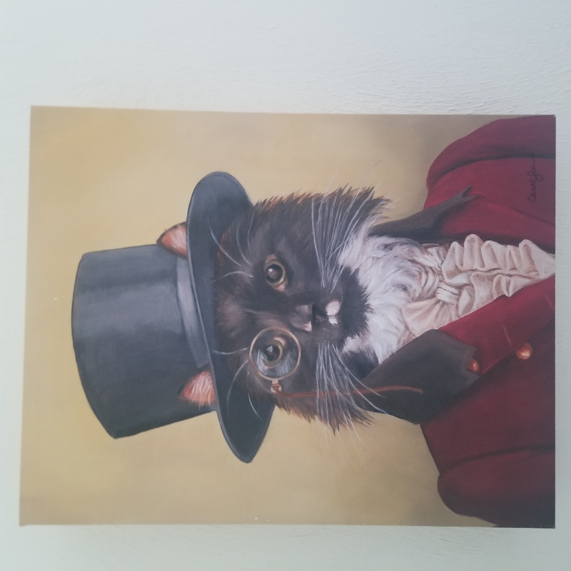 This is a close-up, slightly angled shot of a painting of a cat dressed in formal attire. The cat, which appears to be a black and white tuxedo cat, is wearing a dark top hat that covers its ears, a ruffled white cravat, and a dark red, high-collared jacket. A monocle is perched on its nose. The cat's expression is somewhat stern, with wide, intelligent green eyes. The background is a soft, pale yellow. The painting has a signature in cursive script on the right side, though it is difficult to discern clearly. The overall impression is one of anthropomorphism, presenting the cat as a distinguished gentleman. There are no obvious cues to suggest a specific time of day, weather, or a particular location beyond what is depicted in the painting itself.