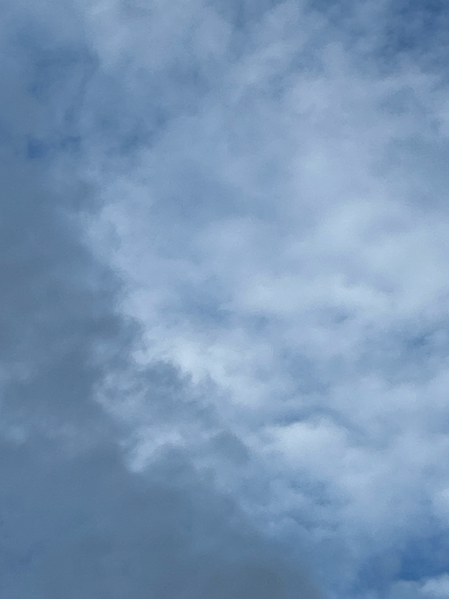 This is a full-frame, close-up, eye-level shot of a cloudy sky. The clouds are a mix of dark gray and lighter, wispy white formations. The lighting suggests it is daytime, possibly overcast. There are no people, animals, buildings, or discernable landmarks visible in the image. The scene is devoid of any specific context that would place it in Robinson Township, United States of America.