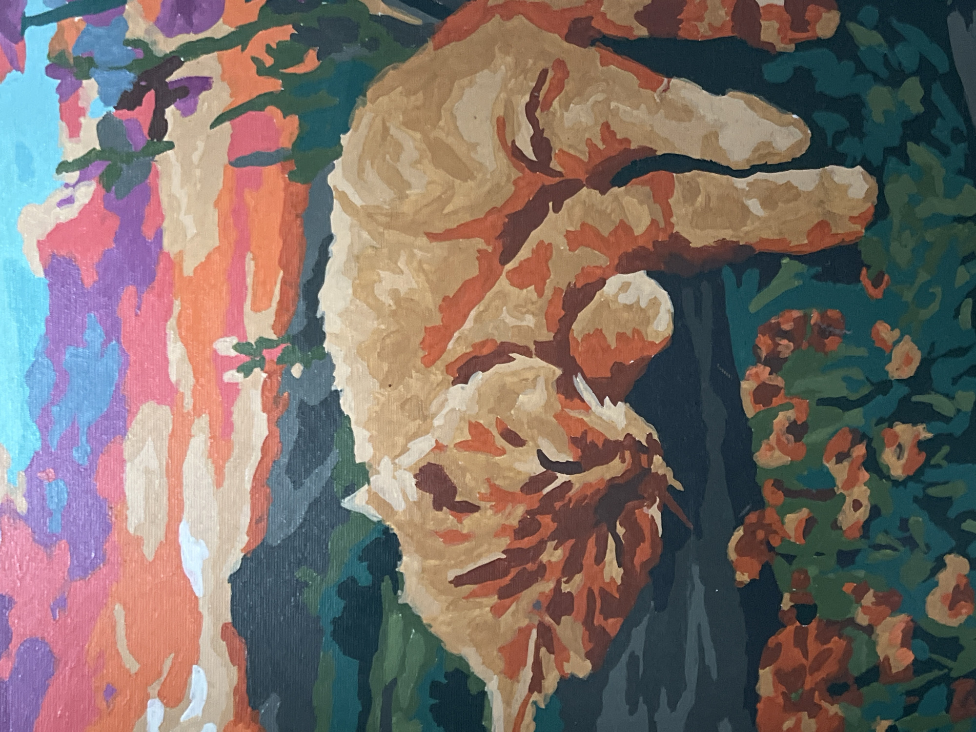 A close-up, head-on shot of a paint-by-numbers artwork depicts a ginger cat sleeping in a garden with a vibrant, multi-colored sky in the background. The cat is the primary subject, positioned centrally and taking up a significant portion of the frame. Its fur is rendered in shades of orange, brown, and cream, with distinct brushstrokes visible, characteristic of this art form. The cat's eyes are closed, and its body is curled, indicating a relaxed state.
In the foreground, a patch of flowers and foliage, painted in various shades of green and orange, surrounds the cat. The flowers are abstractly depicted, consistent with the paint-by-numbers style.
The background features a dramatic sky painted with broad strokes of blues, purples, oranges, and pinks, suggesting a sunset or sunrise. Behind the sky, there are darker, muted shapes that appear to be mountains or hills, painted in shades of green and dark blue. The overall impression is a stylized, somewhat abstract landscape.
The image does not contain any elements that would allow for identification of a specific location within Otradnoye, Russia. The scene is a generic representation of a cat in a natural setting, created through a paint-by-numbers kit. There are no people, animals other than the cat, or specific landmarks present. The style of the artwork is consistent across all elements of the composition.