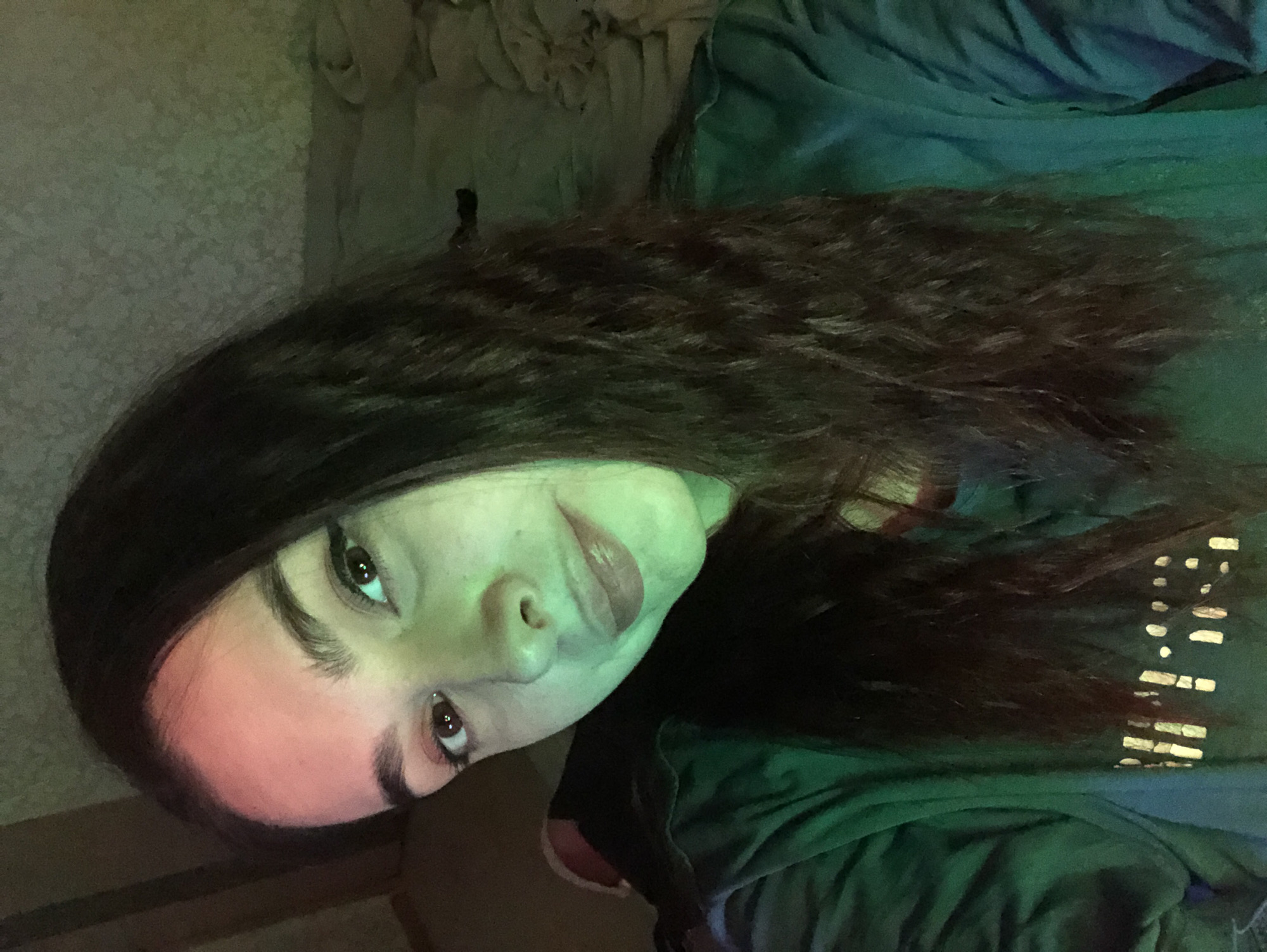 A medium indoor shot depicts a person with dark hair. The person is looking at the camera. The person is wearing a green shirt. The wall is a light green color. The location of the city Noviy, Russia, cannot be ascertained.