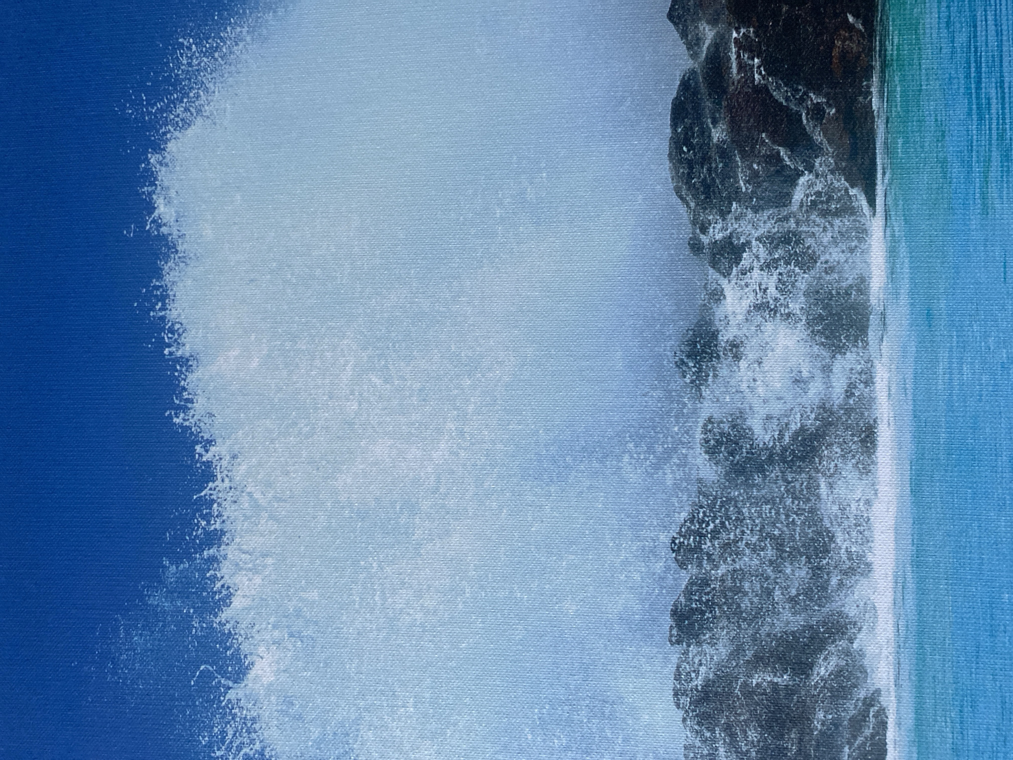 The image depicts a dramatic seascape with a powerful wave crashing against dark, rocky shorelines. The water is a vibrant turquoise, contrasting with the deep blue sky above. White foam and spray erupt from the impact of the wave, creating a dynamic and energetic scene. The texture of the painting, likely canvas, is visible, adding to the artistic rendering of the natural elements. This scene is not specifically located in the city of Nesebar, Bulgaria, but rather captures a generic depiction of a coastal environment. There are no people, specific objects, or actions that would tie it to a particular location.