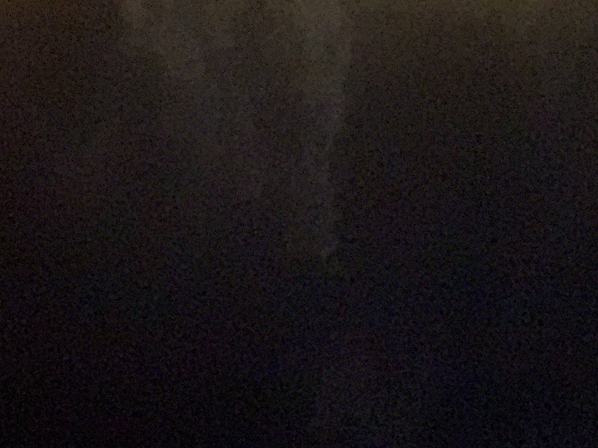 The image is a dark, grainy photograph of what appears to be a rough, textured surface. There is no discernible detail of people, objects, or an environment that would suggest a specific location within Boreti, Montenegro. The lighting is extremely poor, and the image quality is low, making it impossible to identify any specific features.