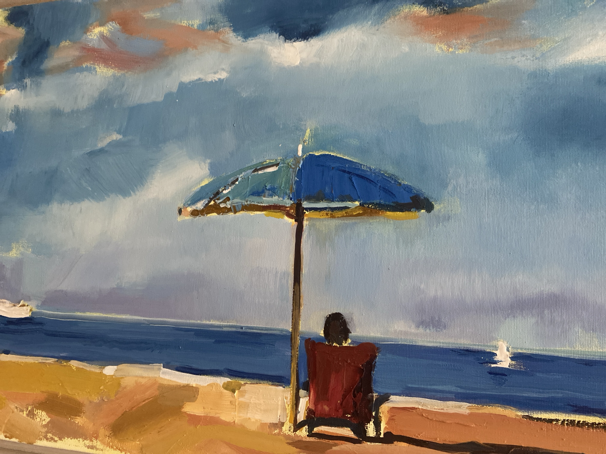 The image is a painting depicting a beach scene. In the foreground, a sandy beach with areas of golden and brown sand is visible, with some white highlights suggesting light reflections or wave crests. A person sits in a red chair under a blue and yellow umbrella, facing the ocean. The umbrella is supported by a brown pole. The middle ground features the deep blue ocean meeting a hazy horizon line. In the distance, a small white sailboat is present on the water. The sky is a mix of blue and white clouds, with hints of pink and yellow, suggesting either sunrise or sunset. The overall style of the painting is impressionistic, with visible brushstrokes and a focus on color and light.
Without additional information or context provided within the image itself, it is impossible to specifically confirm or deny the location of this scene in Sutomore, Montenegro. The painting is a generic representation of a beach and does not contain any identifiable landmarks or specific elements that would tie it to a particular city or country.