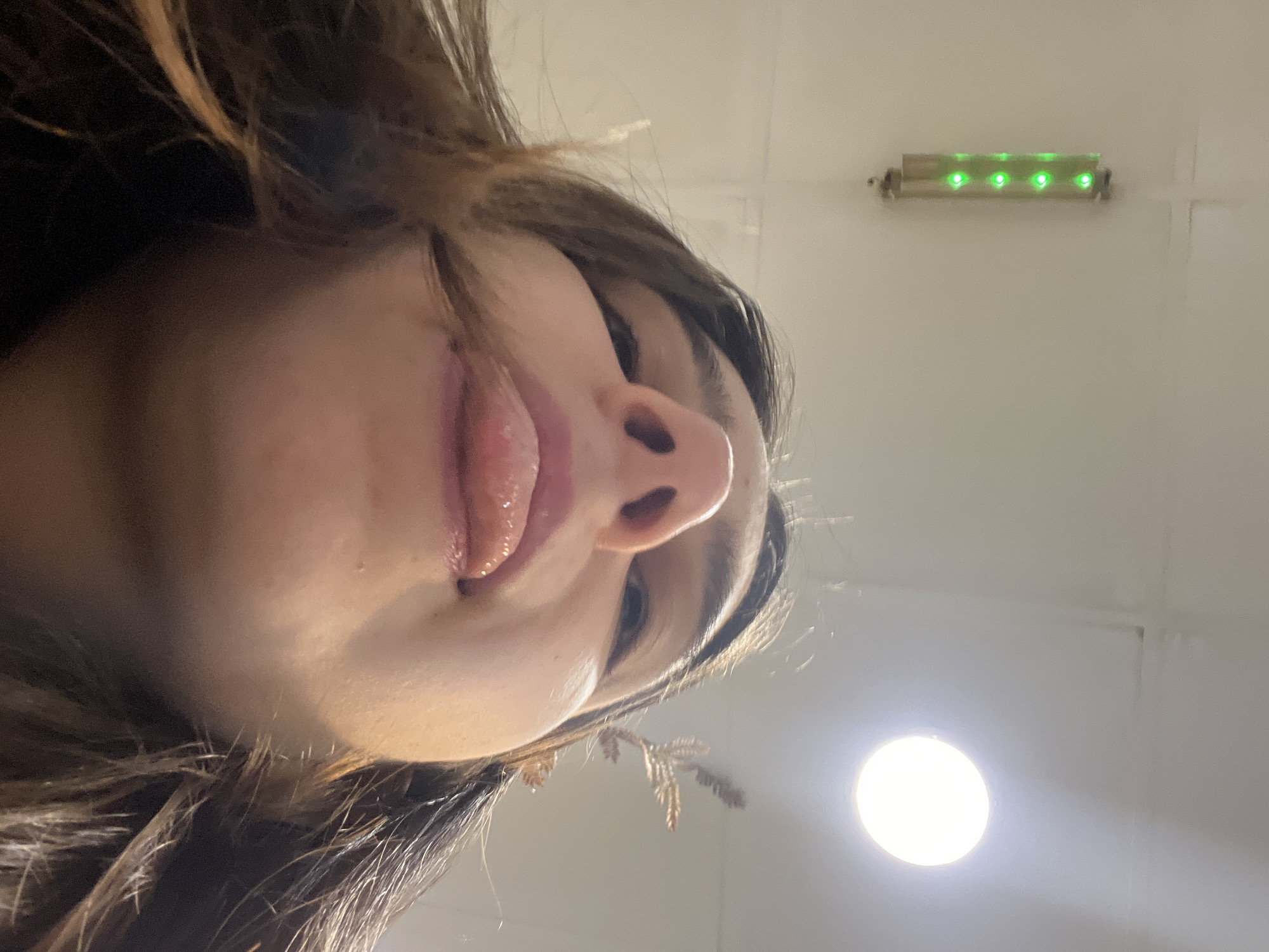 An upward-facing close-up shot of a person's face. The person has dark hair. The lighting appears to be from a ceiling fixture that is visible in the background. A green light fixture is also visible in the background. The specific location within Sofia, Bulgaria, cannot be determined from the image.