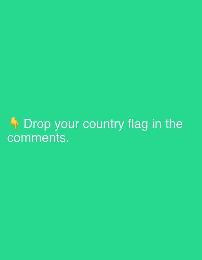 The image is a graphic with a bright green background. In the lower left quadrant, there is a yellow pointing finger emoji. To the right of the emoji, in white text, are the words "Drop your country flag in the comments." The text is in a sans-serif font and appears to be centered. The image is simple and text-based, likely intended to prompt engagement on a social media platform. There are no other discernible subjects, objects, or scene elements. The setting is a plain, solid color background. No specific time of day, weather, or location cues are visible beyond what might be inferred from the text itself. The overall emotion conveyed is one of invitation and interaction.