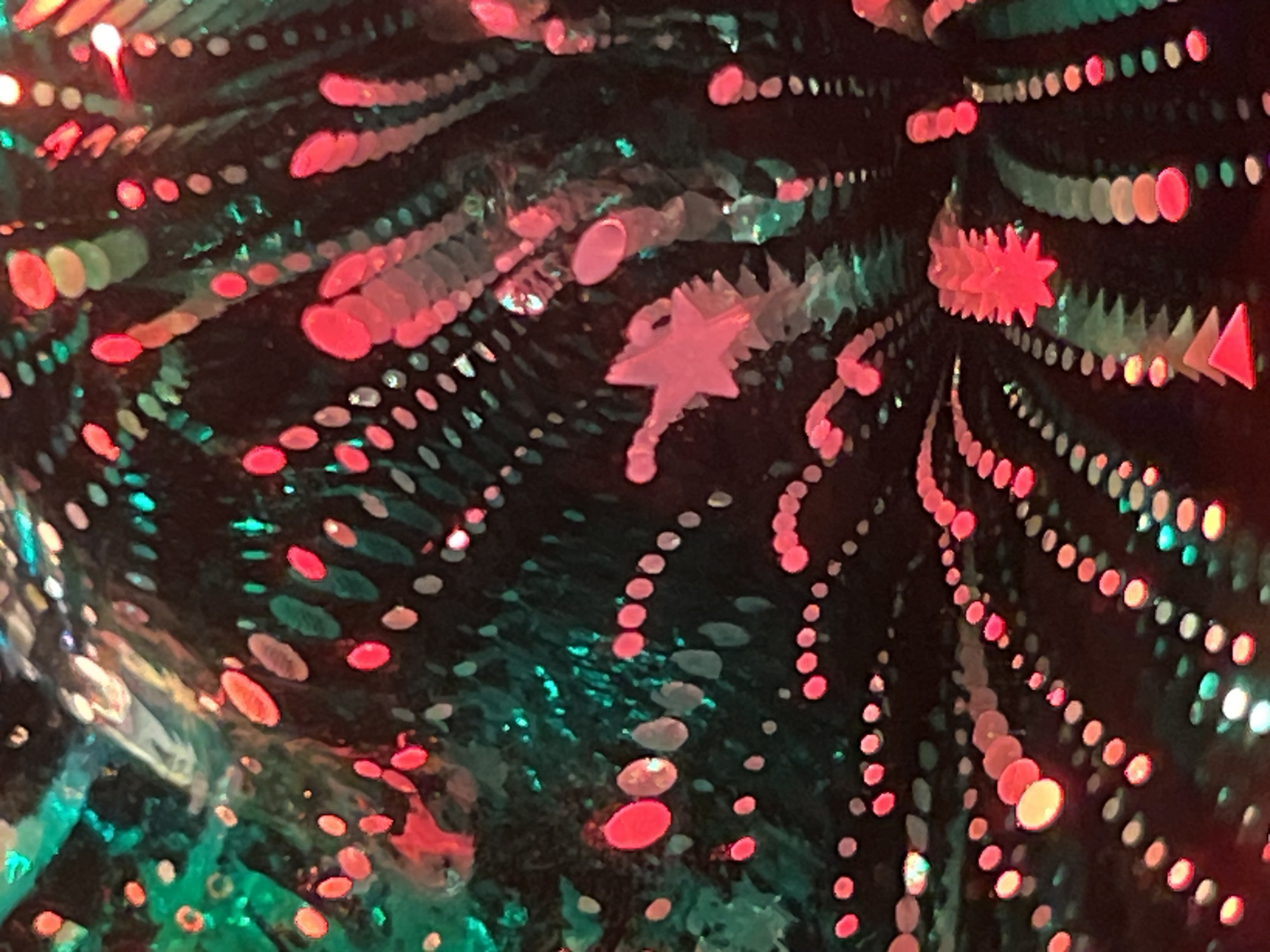 The image shows a psychedelic and abstract pattern of colorful lights, primarily red and green, against a dark background. The lights are arranged in various shapes and sizes, creating a sense of depth and movement. Some lights appear as dots, while others are elongated or have more complex forms. There are no discernible people or recognizable objects in the scene. The overall impression is one of a vibrant and dreamlike display of light art. The location is Unknown, Unknown.