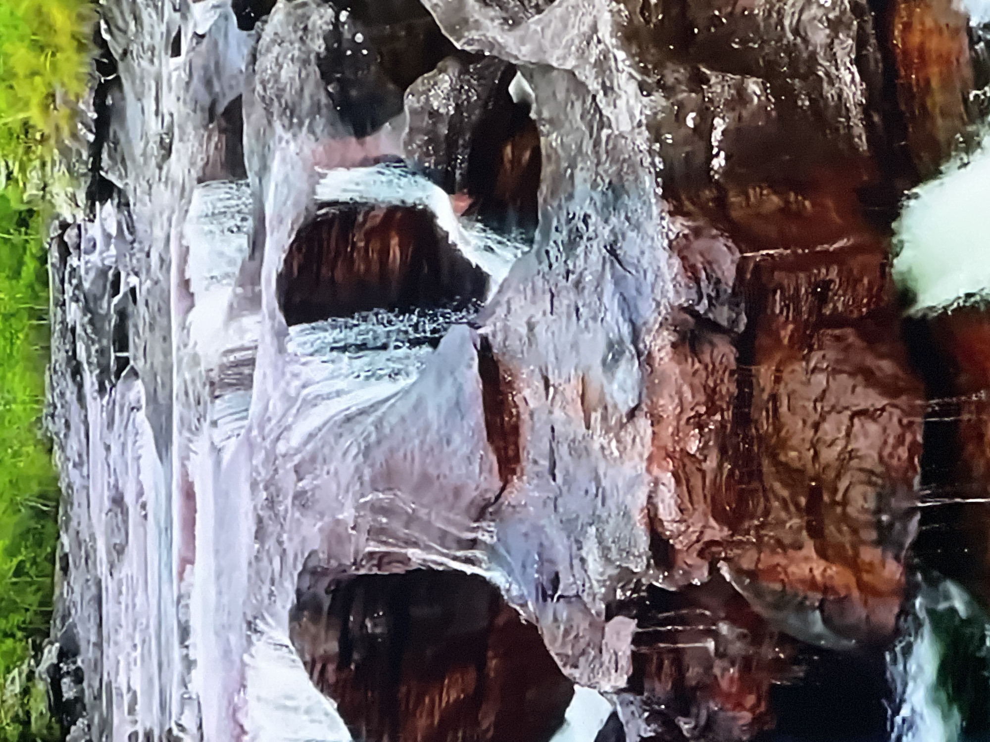 The image depicts a natural landscape featuring a rocky riverbed with water flowing over the rocks, creating small cascades. The rocks are varied in color, with shades of brown, gray, and some reddish tones. The water appears somewhat milky and turbulent in places. In the background, lush green foliage can be seen, suggesting a natural, possibly forested, environment. The lighting indicates it is daytime. The scene is solely focused on the river and its immediate surroundings, with no man-made structures or human presence visible.
There is no identifiable connection to Casablanca, Morocco. The landscape is not characteristic of the city or its surroundings.