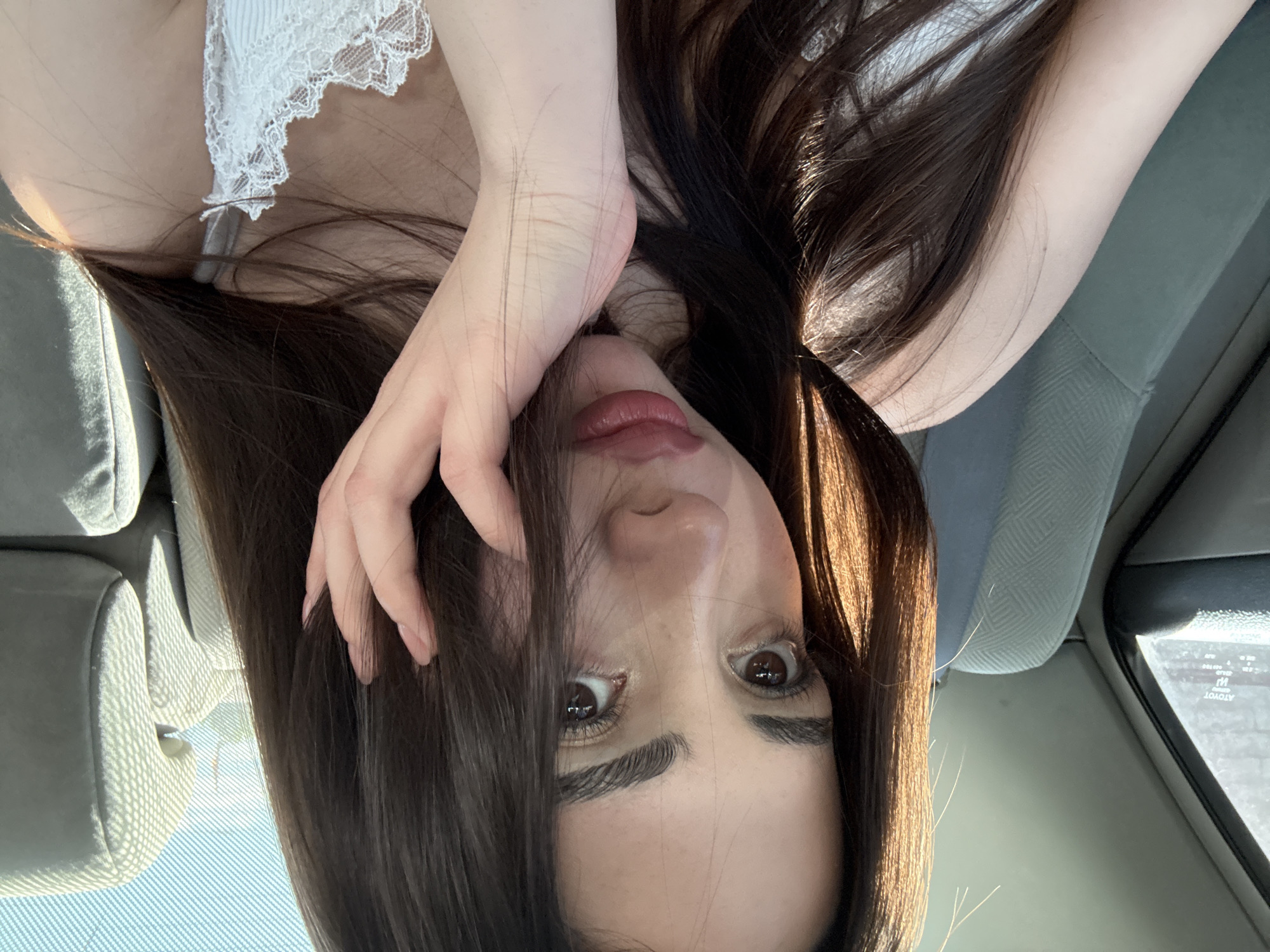 A female individual is positioned in what appears to be the front seat of a vehicle. She is facing the camera, holding her hand up near her face. The vehicle's interior, including the seats and door, are visible. The image doesn't contain information to confirm or deny its location in Yerevan, Armenia.
