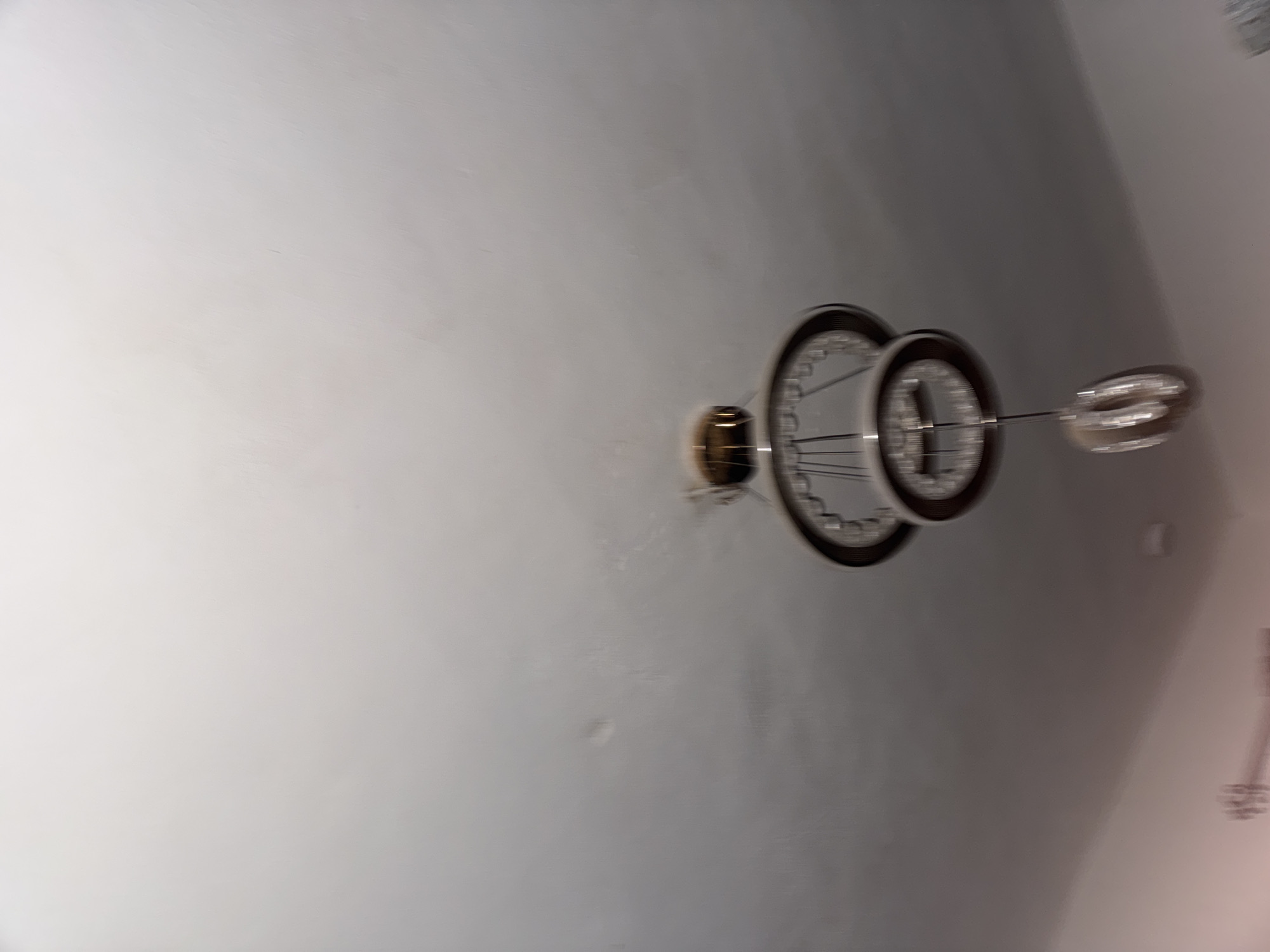 The image shows a ceiling with a chandelier. The chandelier has a gold-colored base, two concentric circular rings, and three glass bulbs extending from the rings. The ceiling is white or light gray in color. The location, Ihiagwa, Nigeria, is not directly discernible from the image.