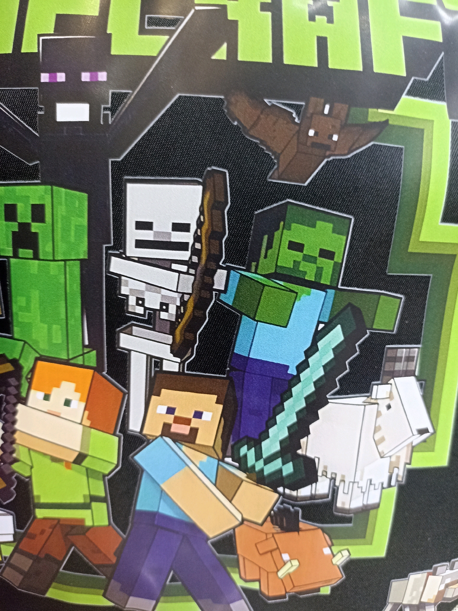 This is a close-up, eye-level shot of a graphic print featuring characters from the video game Minecraft. The print depicts several iconic Minecraft creatures and figures arranged in a dynamic composition.
On the left, a green Creeper is visible. To its right, a black Enderman stands tall with its distinctive purple eyes. Next to the Enderman is a white Skeleton holding a bow. A brown Bat is flying in the upper right quadrant of the image. A green-skinned Zombie wielding a sword made of blocks stands prominently in the center, facing left. In the foreground, two human characters, Alex (with orange hair and a green shirt) and Steve (with brown hair and a blue shirt), are walking towards the right. A white Sheep is positioned behind the Zombie, and an orange Pig is in the lower right foreground.
The background is dark with some out-of-focus lime green geometric shapes that resemble lightning or abstract design elements. The characters are rendered in the blocky, pixelated style characteristic of Minecraft.
There is no discernible time of day, weather, or specific location cues within the image itself, as it appears to be a graphic design rather than a depiction of a real-world scene. The overall impression is one of action and the gathering of familiar game elements. Visible text at the very top of the image, though partially cut off and out of focus, appears to be the word "MINECRAFT" in large, blocky letters.