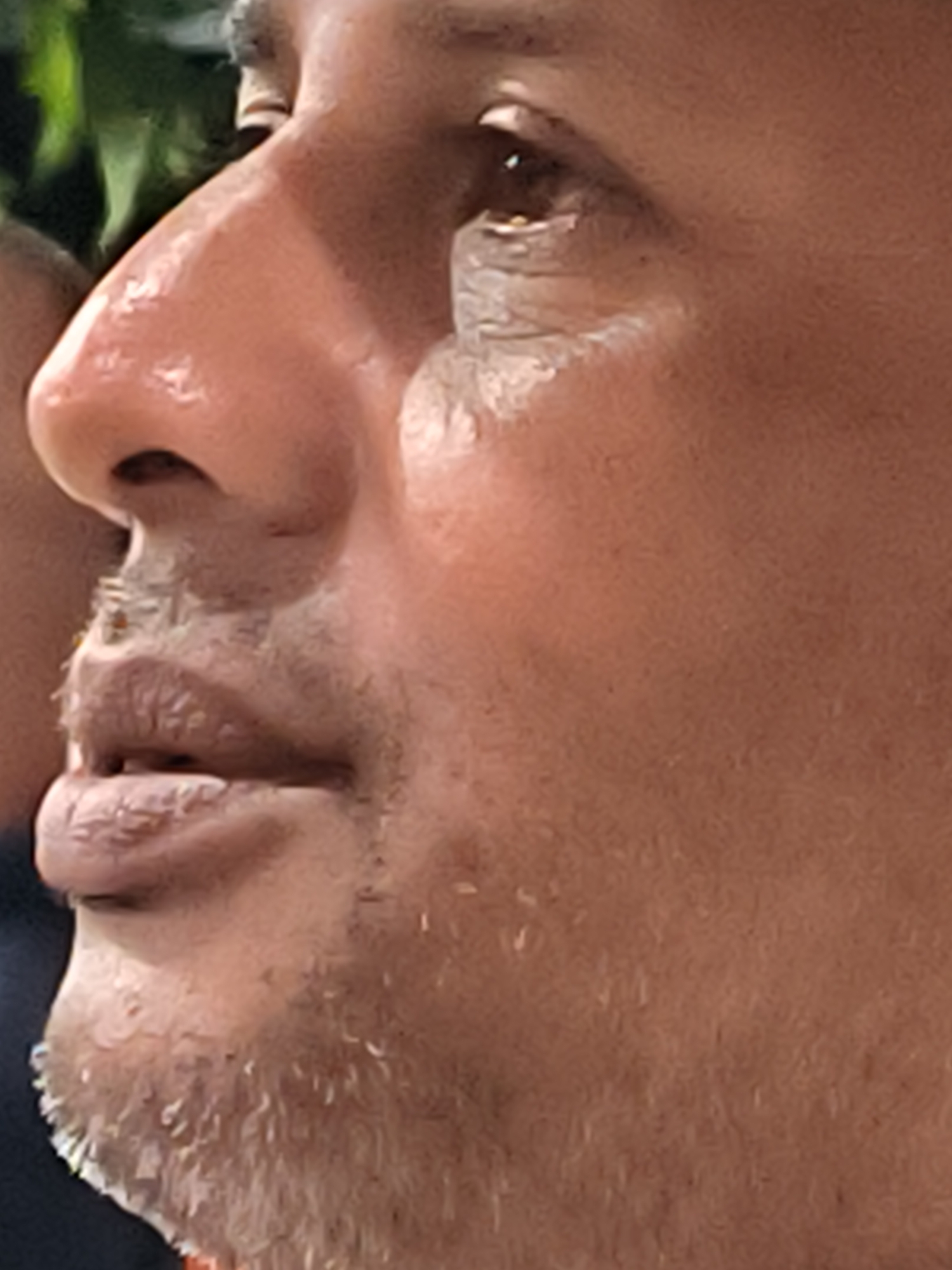 A close-up shot of a man's face in profile. The man has a light brown skin tone, a slightly stubbled beard, and a few wrinkles around his eye. The location is not discernible from this image.
