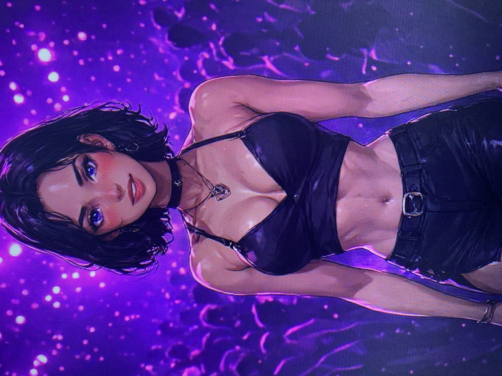 The image is a digital illustration of a young woman with dark hair, blue eyes, and fair skin. She is wearing a black halter top, black shorts, a black choker necklace with a pendant, and hoop earrings. Her abdomen is exposed, and she has a navel piercing. She is standing in front of a blurred background of purple lights and silhouettes of people. The style of the image is anime-inspired, with exaggerated features and vibrant colors. The image does not contain any elements that would allow for the identification of a specific location in Yerevan, Armenia, or any other city.