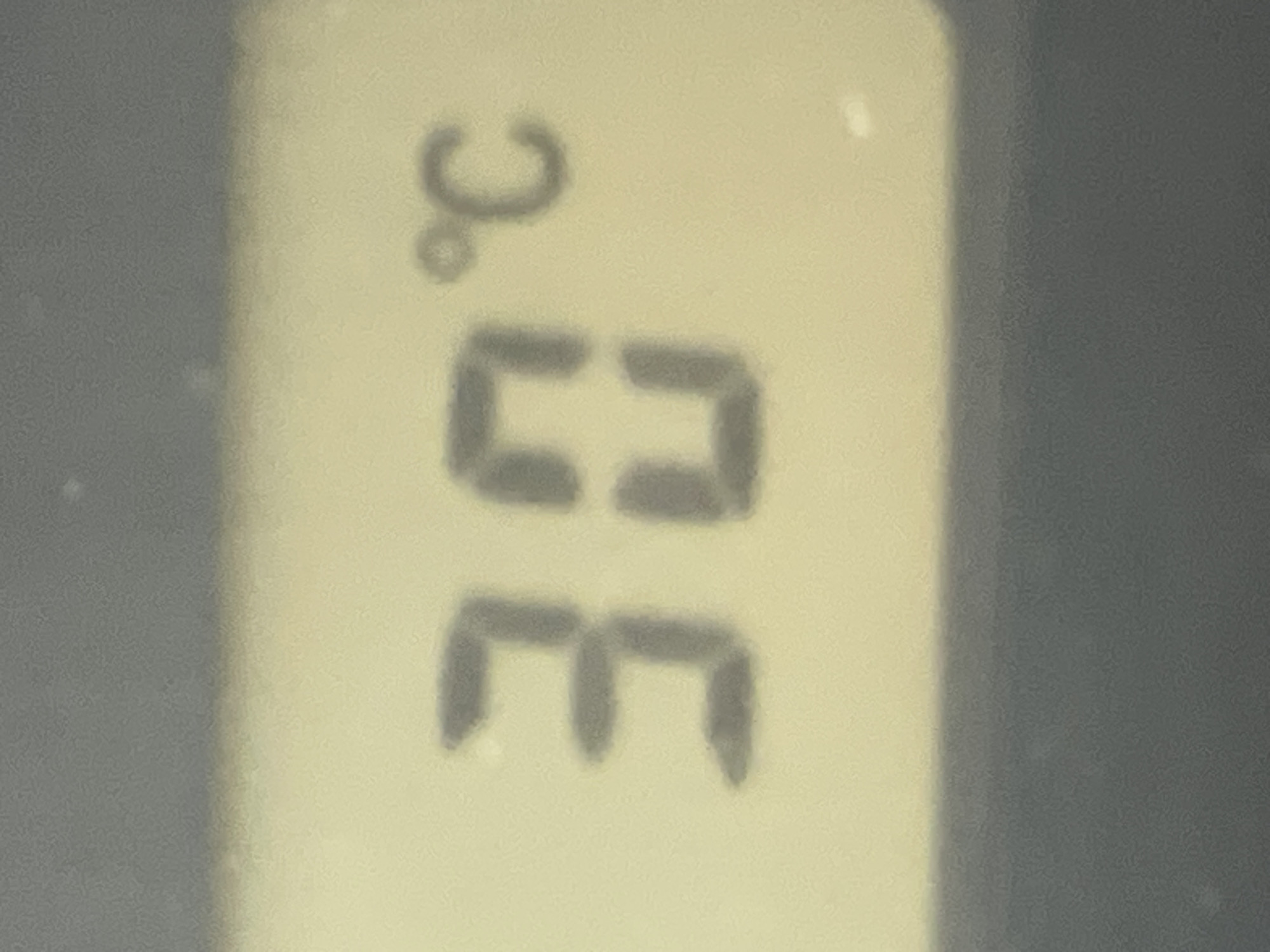 The image displays a close-up view of a digital display showing a temperature reading of 30°C. The numbers "30" are prominently visible in a dark gray color against a pale yellow background. To the right of the numbers, the degree symbol (°C) is also depicted in the same dark gray color. The overall image is slightly blurred, indicating it was likely taken with a handheld device. The background behind the display appears to be a dark gray, possibly the casing of the device. The image does not contain any information about the city of Sochi, Russia, or any other geographical location.
