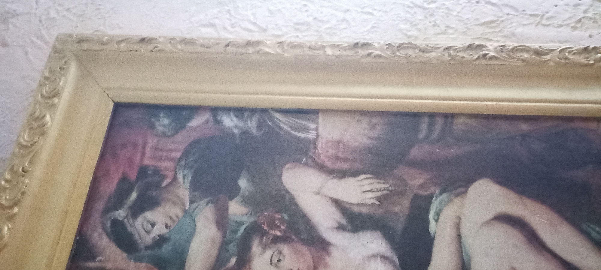 The image shows a framed painting. The painting depicts a group of people, possibly women, in what appears to be an indoor setting. The figures are rendered in a style that suggests a classical or academic art period. One figure in the foreground is looking towards the viewer with a somewhat somber expression, while others are partially obscured and appear to be reclining or interacting with each other. The color palette is rich, with prominent use of deep reds and blues, and the lighting seems to be artificial or studio-like. The frame is ornate and golden, suggesting it is a decorative piece. The context provided places the image in Kryvyi Rih, Ukraine. No text is visible in the image.