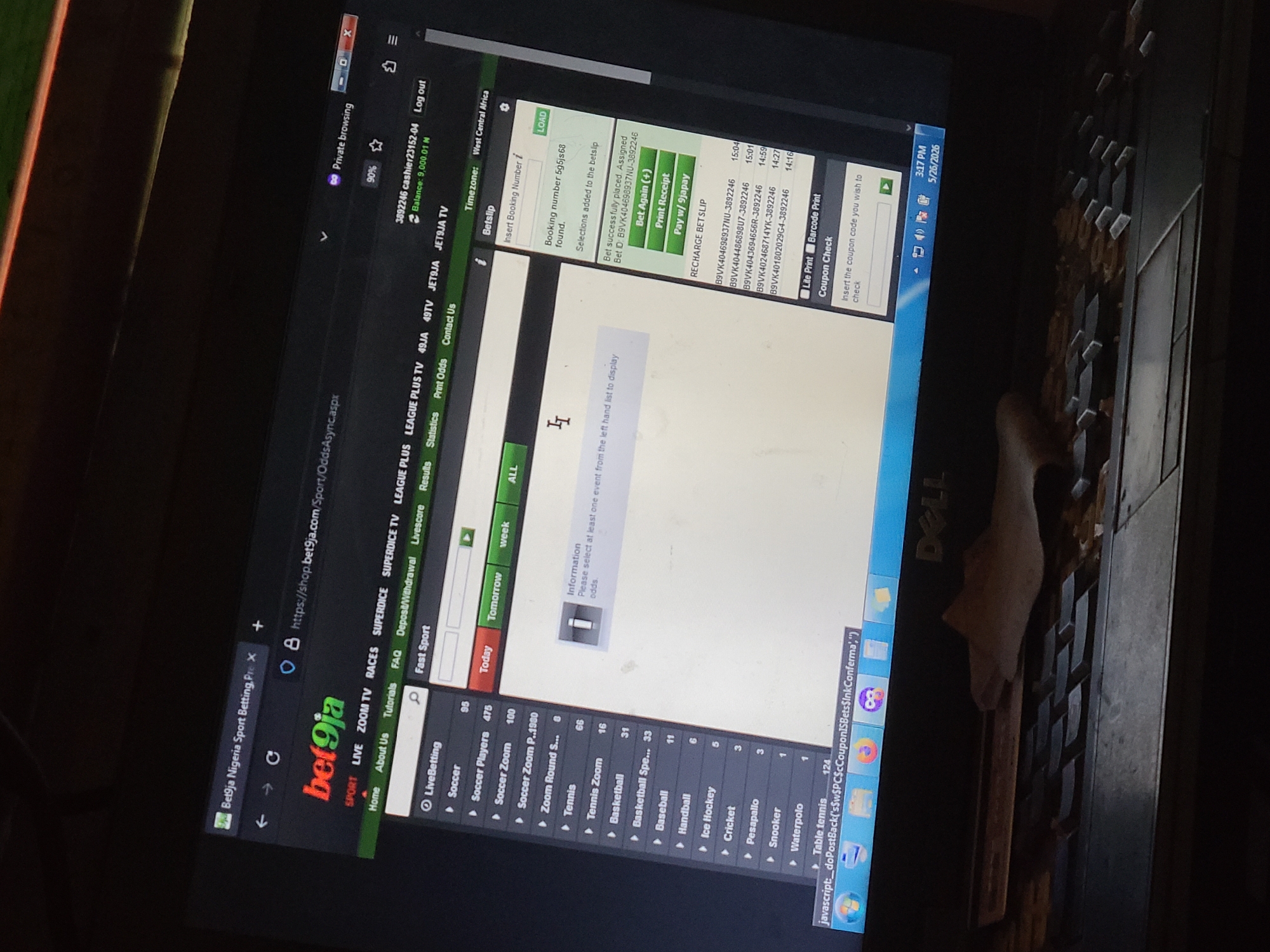 A close-up shot depicts a Dell laptop screen displaying the Bet9ja website, an online sports betting platform, with the URL visible as "https://shop.bet9ja.com/Sport/OddsAsync.aspx." The user appears to be logged into an account identified as "3892246 cashier23152-04" with a balance of "9,000.01 N" (Naira). The site is set to "West Central Africa" timezone. The user is viewing live betting options, with sports listed on the left-hand panel, including soccer, tennis, basketball, and others. The screen shows a betslip with a booking number and selections added. A "Print Receipt" and "Pay w/9japay" button are visible. A "Coupon Check" section is available. The laptop keyboard is partially visible with a tissue or cloth next to it. The time is displayed as "3:17 PM" and the date as "5/26/2026." The location is Unknown, Unknown.