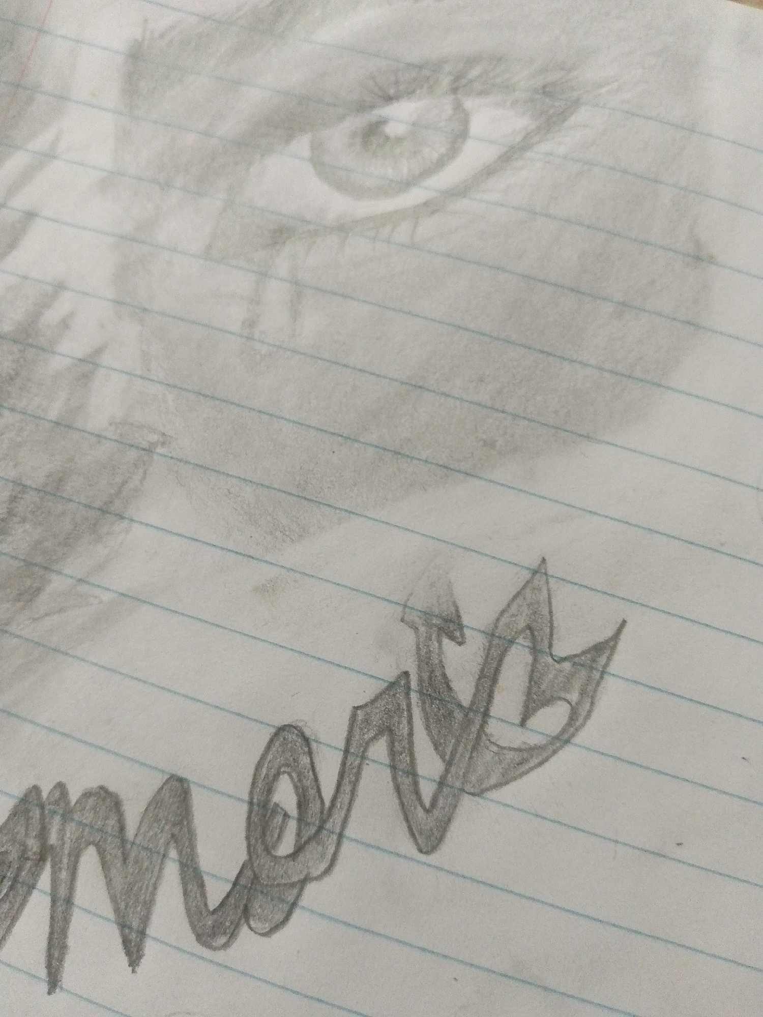 A close-up, slightly angled view of a pencil drawing on lined paper. The drawing depicts an eye and a portion of a face above the word "memory" written in stylized, cursive lettering. The location in Juan Griego, Venezuela is not ascertainable from the visual information.