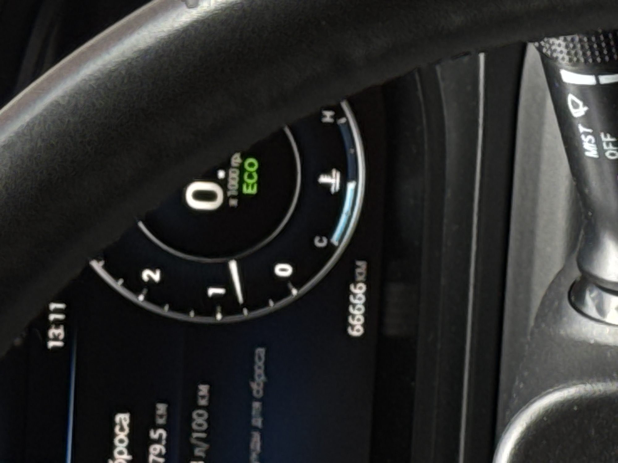 The image shows the dashboard of a car. The car's odometer reads 66666 km. The time displayed on the dashboard is 13:11. The engine is running in ECO mode, with the tachometer at 0 RPM. The ambient temperature indicator is visible. The windscreen wiper control stalk is also in the frame. Location: The car is in Russia.