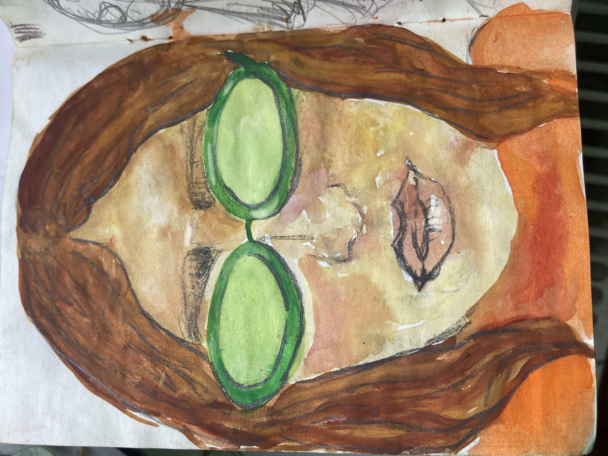 A watercolor and pencil sketch on white paper depicts a person lying down, viewed from above. The person has brown hair framing their face. Two green oval objects, possibly cucumber slices, are positioned over their eyes. A smaller, leaf-shaped object is near the cheek. The facial area is painted in washes of yellow and brown, while the hair is rendered in shades of brown with darker outlines. The background is indeterminate. There is no indication of the location being Maidstone, United Kingdom, or any other specific city.