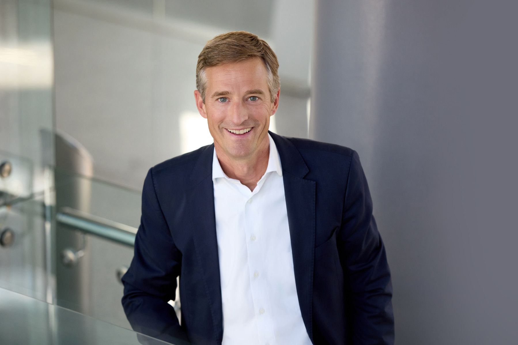 Portrait of Max Kownatzki, CEO of Eurowings, smiling in a modern office building.
