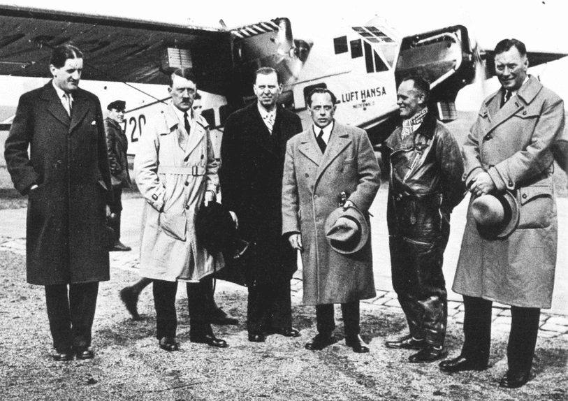Adolf Hitler und andere Mitglieder der nationalsozialistischen Partei vor Hitlers Lufthansa-Flugzeug D-1720.