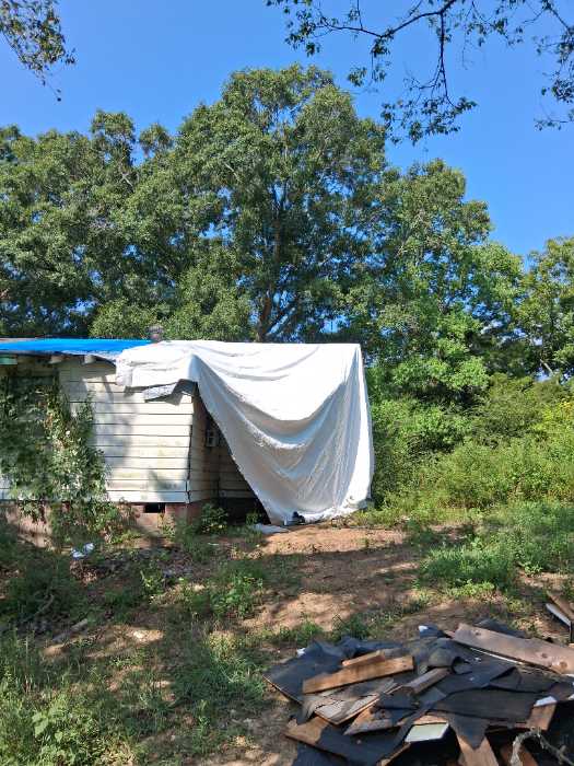 Install temporary waterproof barrier over exposed framing on roof system in Terry, MS