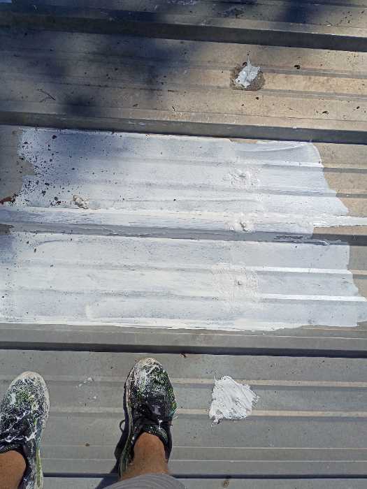 Priming rust spots on metal roof to get ready for silicone in Madison, MS, photo 4