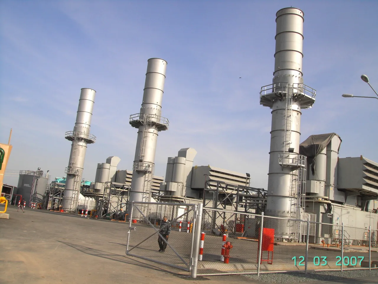 Gas turbine generating units with exhaust stacks and air intake filters at a power plant