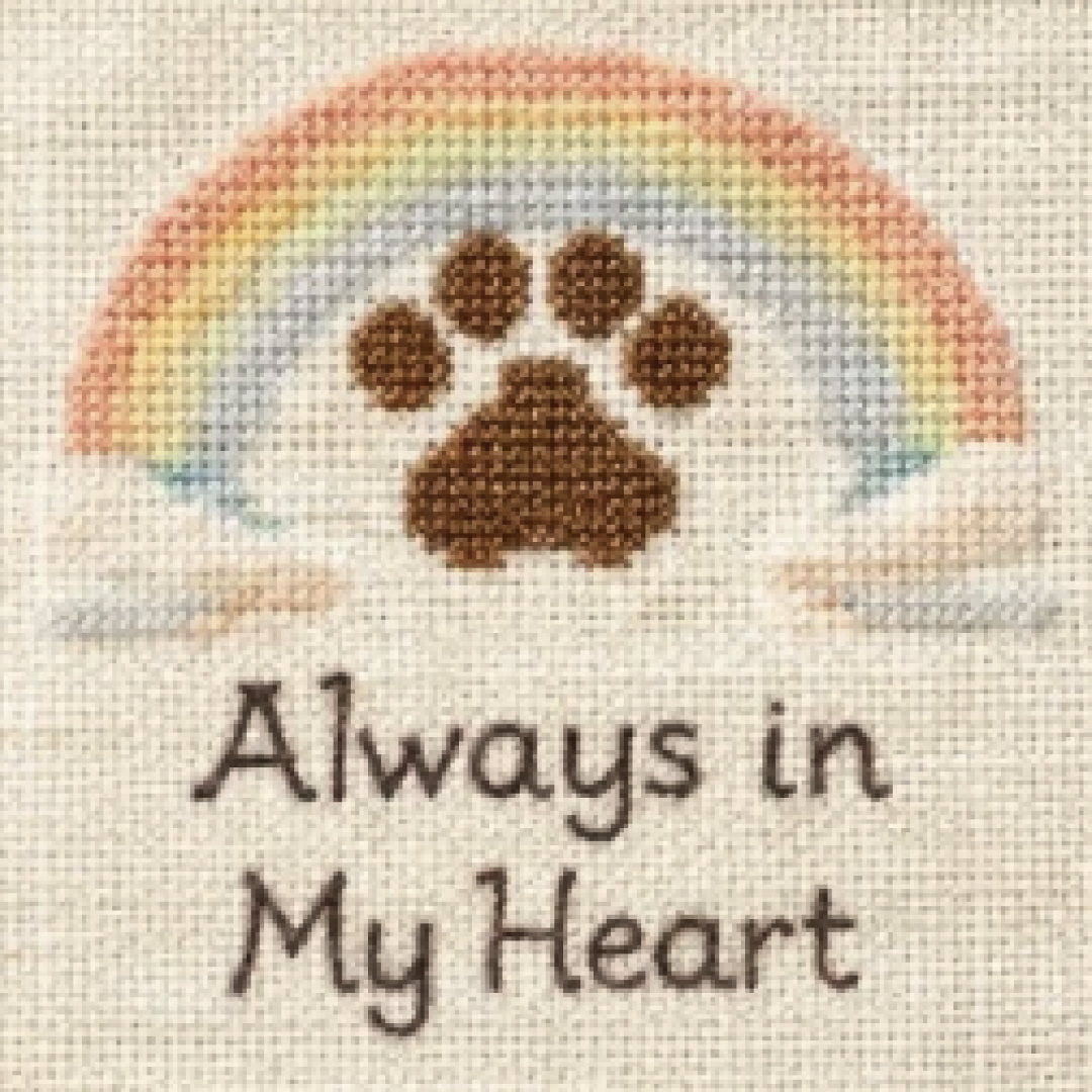Rainbow, clouds and a paw print memorial rendered as a cross stitch pattern