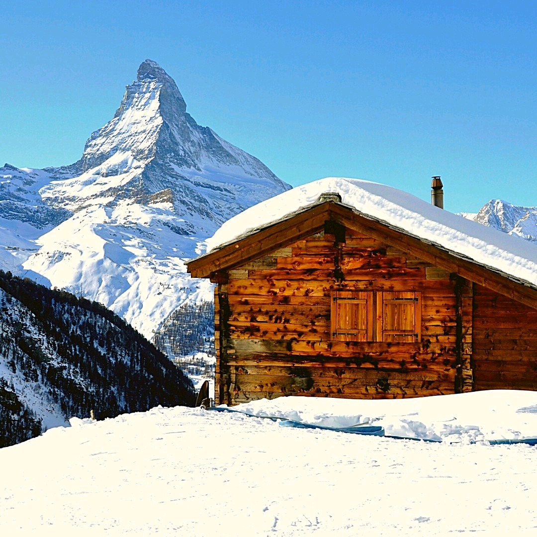 Das Matterhorn hinter einer schneebedeckten Berghütte in Zermatt