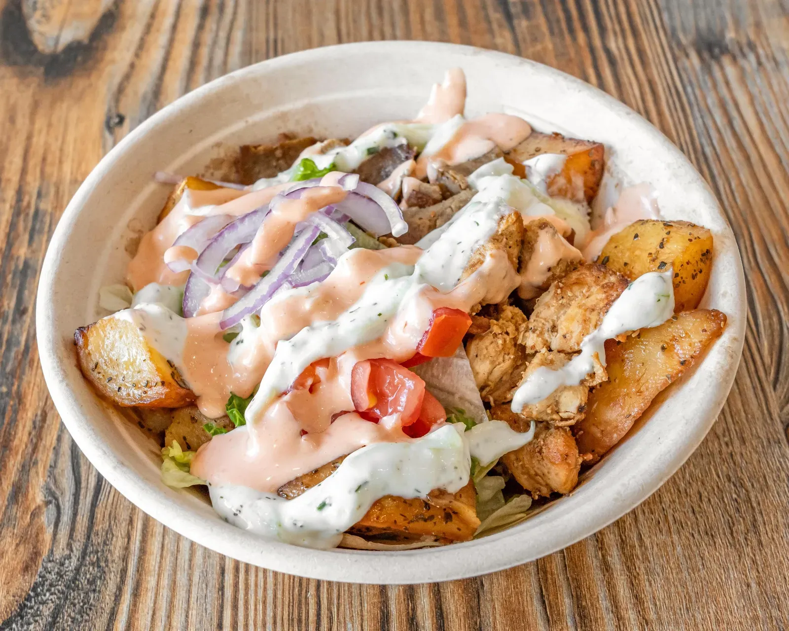 The Olympian Bowl: lemon potatoes topped with gyro, chicken souvlaki, tzatziki and pita sauce