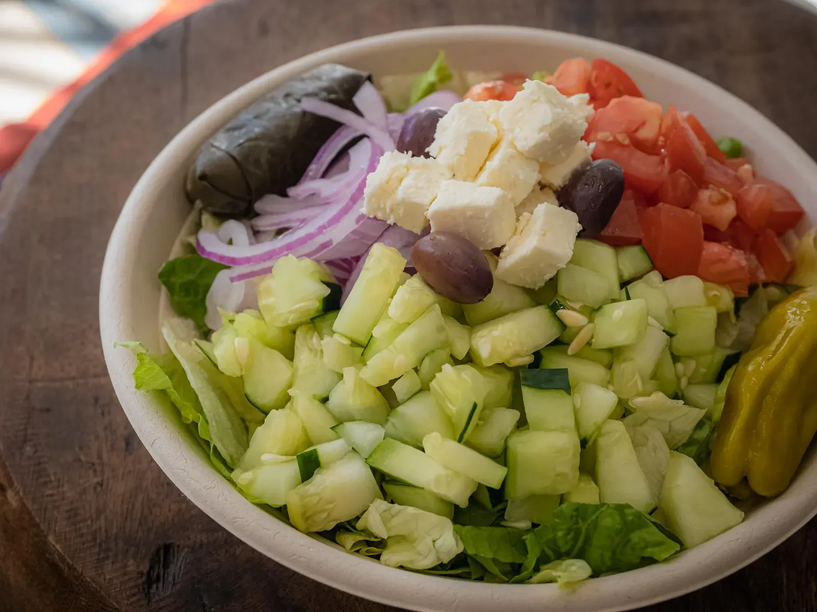 It’s Greek To Me salad with lettuce, cucumber, tomato, feta, kalamata olives and a grape leaf