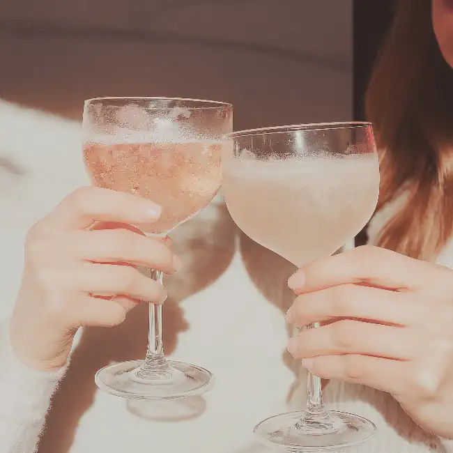 Toasting with two coupe glasses of champagne