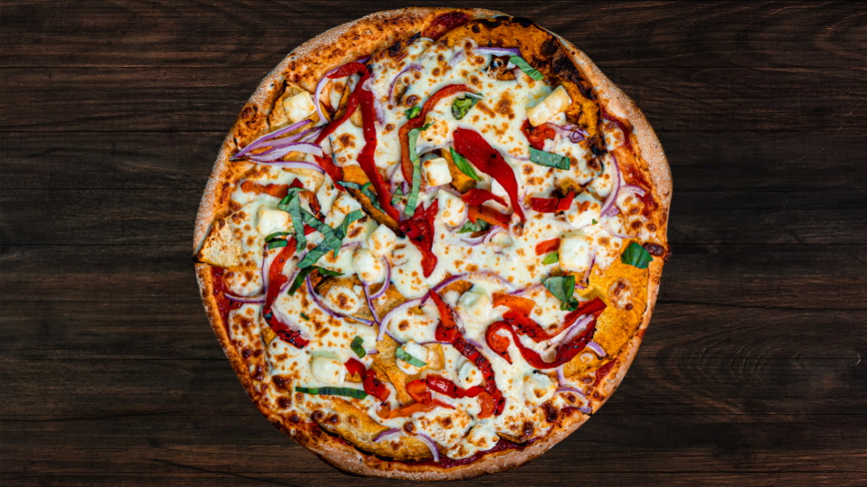 A pumpkin pizza with feta and basil