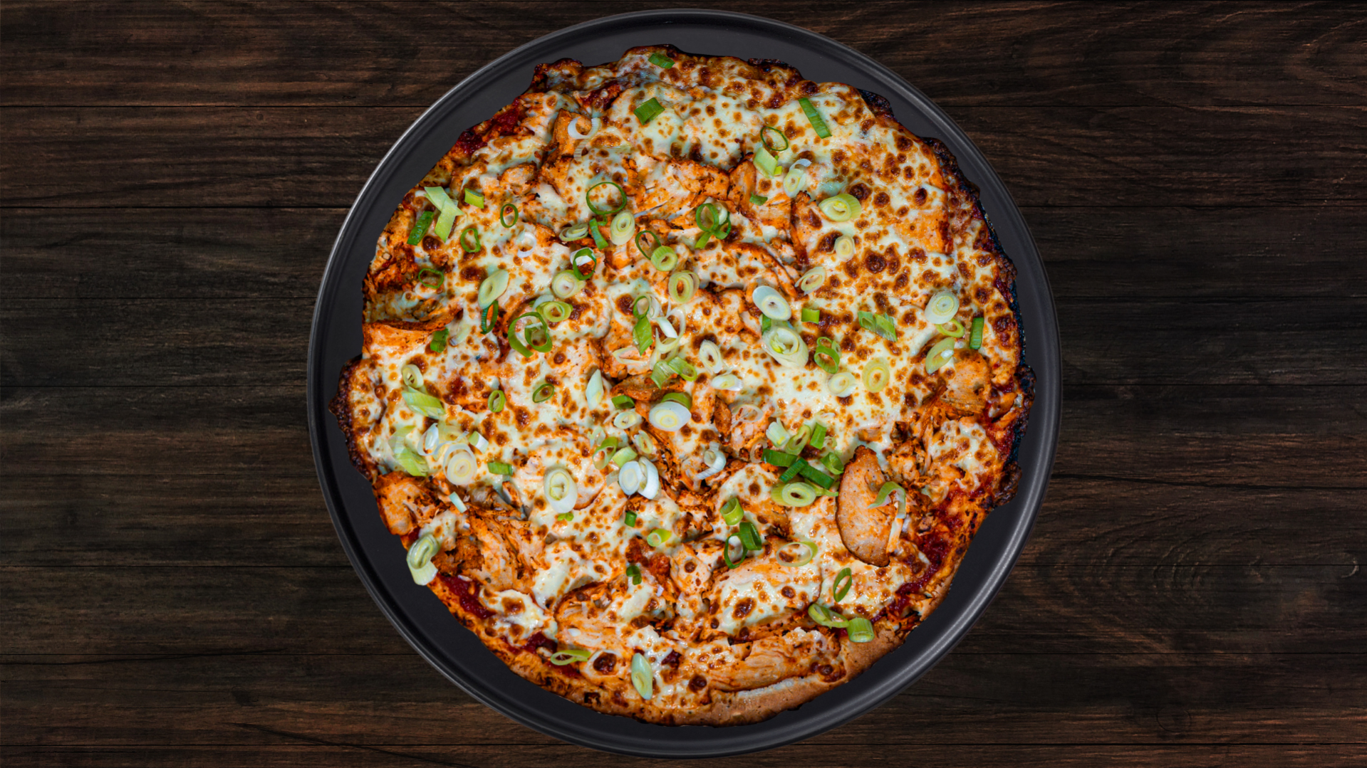 A Tandoori chicken pizza with a side of yogurt dip