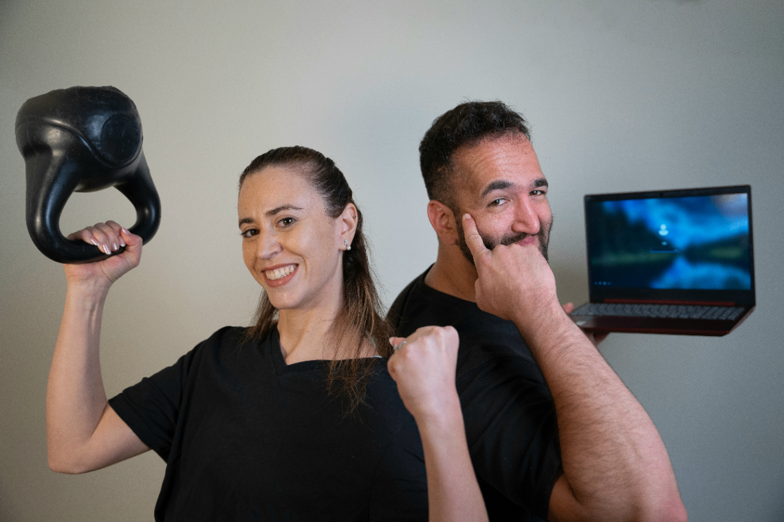 שני עמיתים במשרד מסתכלים על מסך של לפטופ בחיוך