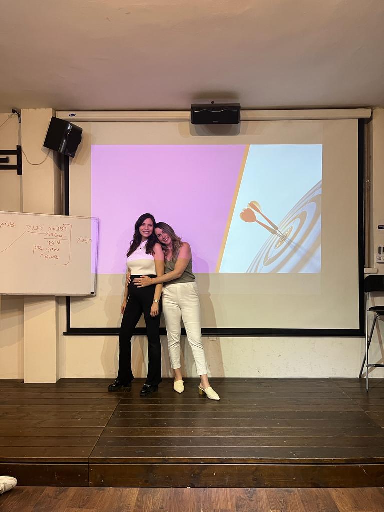 שני עמיתים במשרד מסתכלים על מסך של לפטופ בחיוך