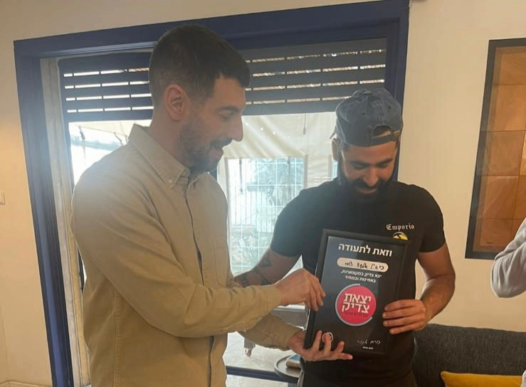 שני עמיתים במשרד מסתכלים על מסך של לפטופ בחיוך